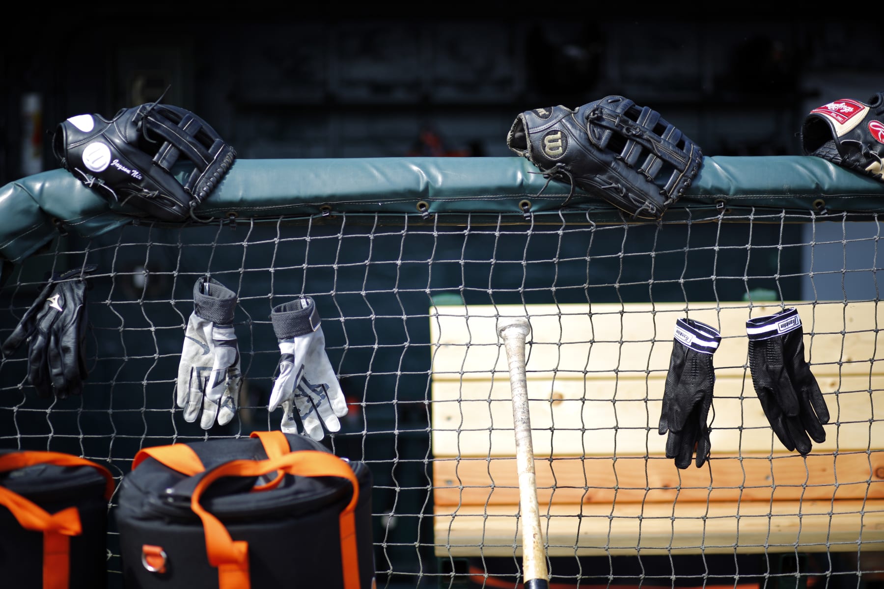 Baltimore Orioles equipment hangs on a their dugout fence in front of their dugout before before a spring training exhibition baseball game against the Detroit Tigers in Lakeland, Fla., Tuesday, March 3, 2015. (AP Photo/Gene J. Puskar)