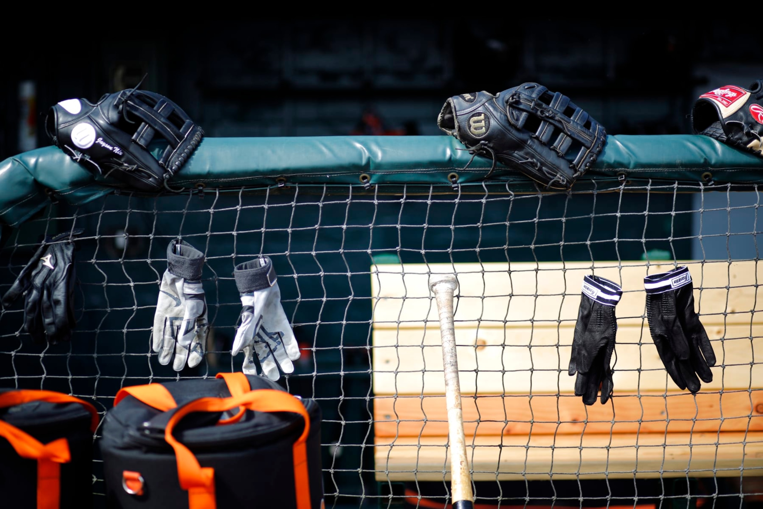 Baltimore Orioles equipment hangs on a their dugout fence in front of their dugout before before a spring training exhibition baseball game against the Detroit Tigers in Lakeland, Fla., Tuesday, March 3, 2015. (AP Photo/Gene J. Puskar)