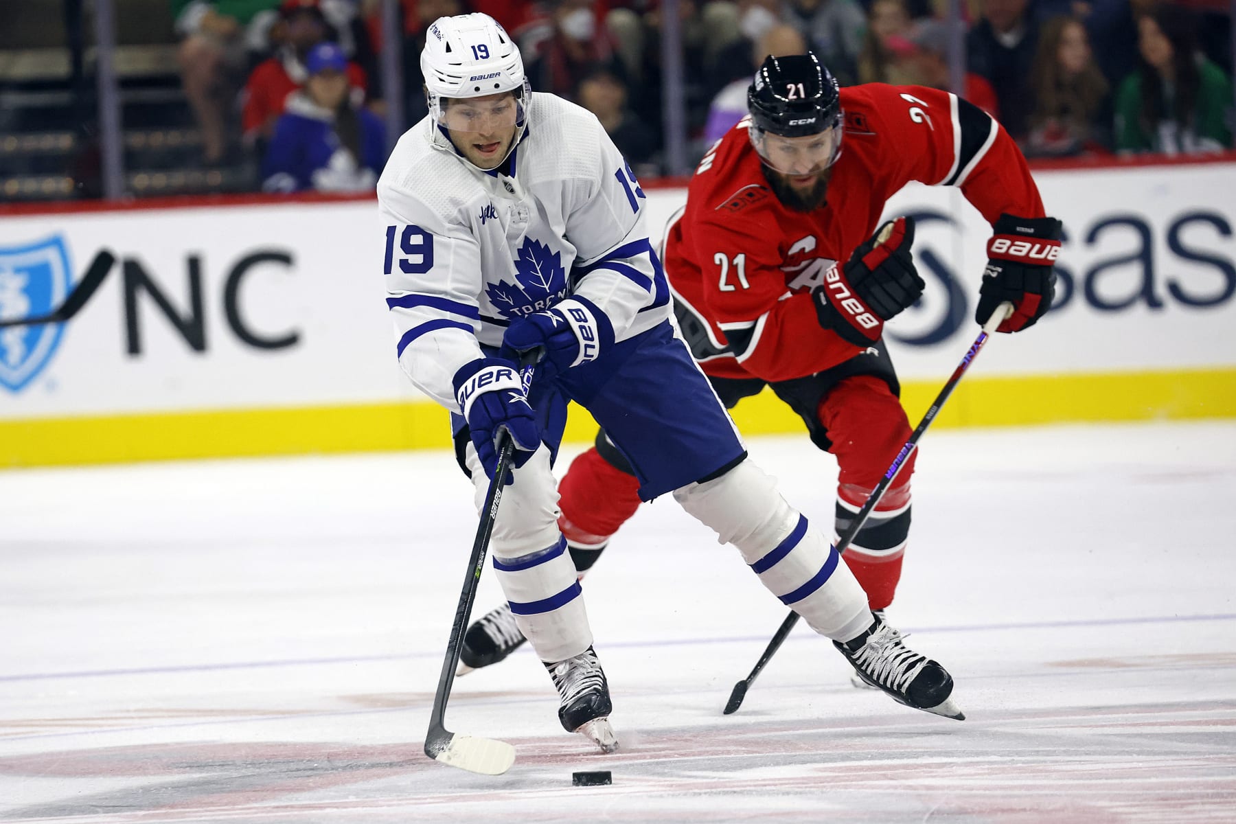 Toronto Maple Leafs' Calle Jarnkrok (19) controls the puck in front of Carolina Hurricanes' Derek Stepan (21) during the first period of an NHL hockey game in Raleigh, N.C., Sunday, Nov. 6, 2022. (AP Photo/Karl B DeBlaker)