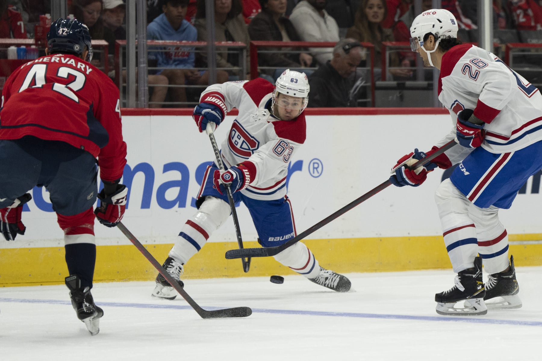 Montreal Canadiens right wing Evgenii Dadonov (63) passes the puck past defenseman Johnathan Kovacevic (26) and Washington Capitals defenseman Martin Fehervary (42) during the first period of an NHL hockey game, Saturday, Oct. 15, 2022, in Washington. (AP Photo/Jess Rapfogel)