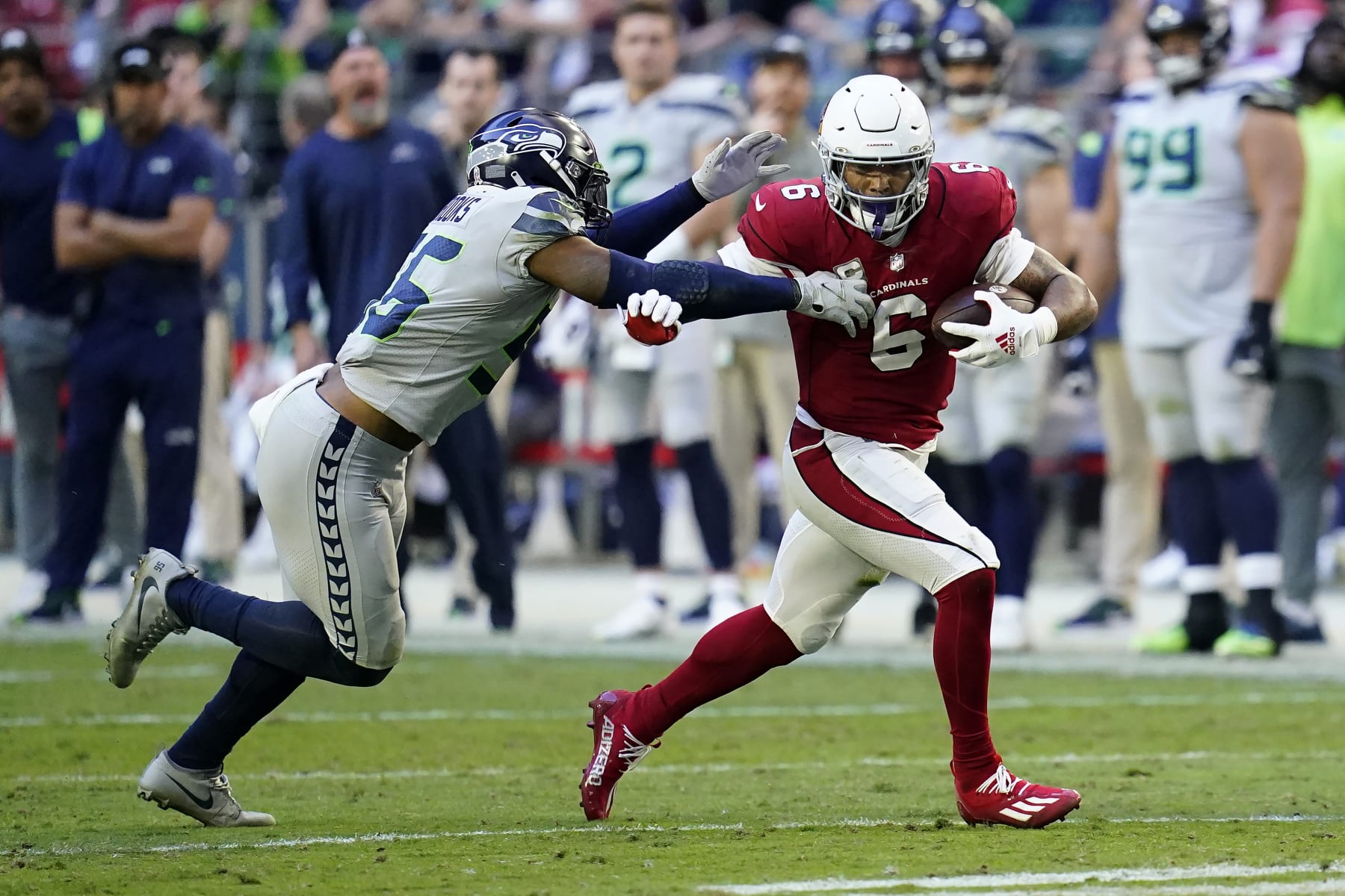 Arizona Cardinals running back James Conner (6) runs against Seattle Seahawks linebacker Jordyn Brooks during an NFL football game in Glendale, Ariz., Sunday, Nov. 6, 2022. (AP Photo/Ross D. Franklin)
