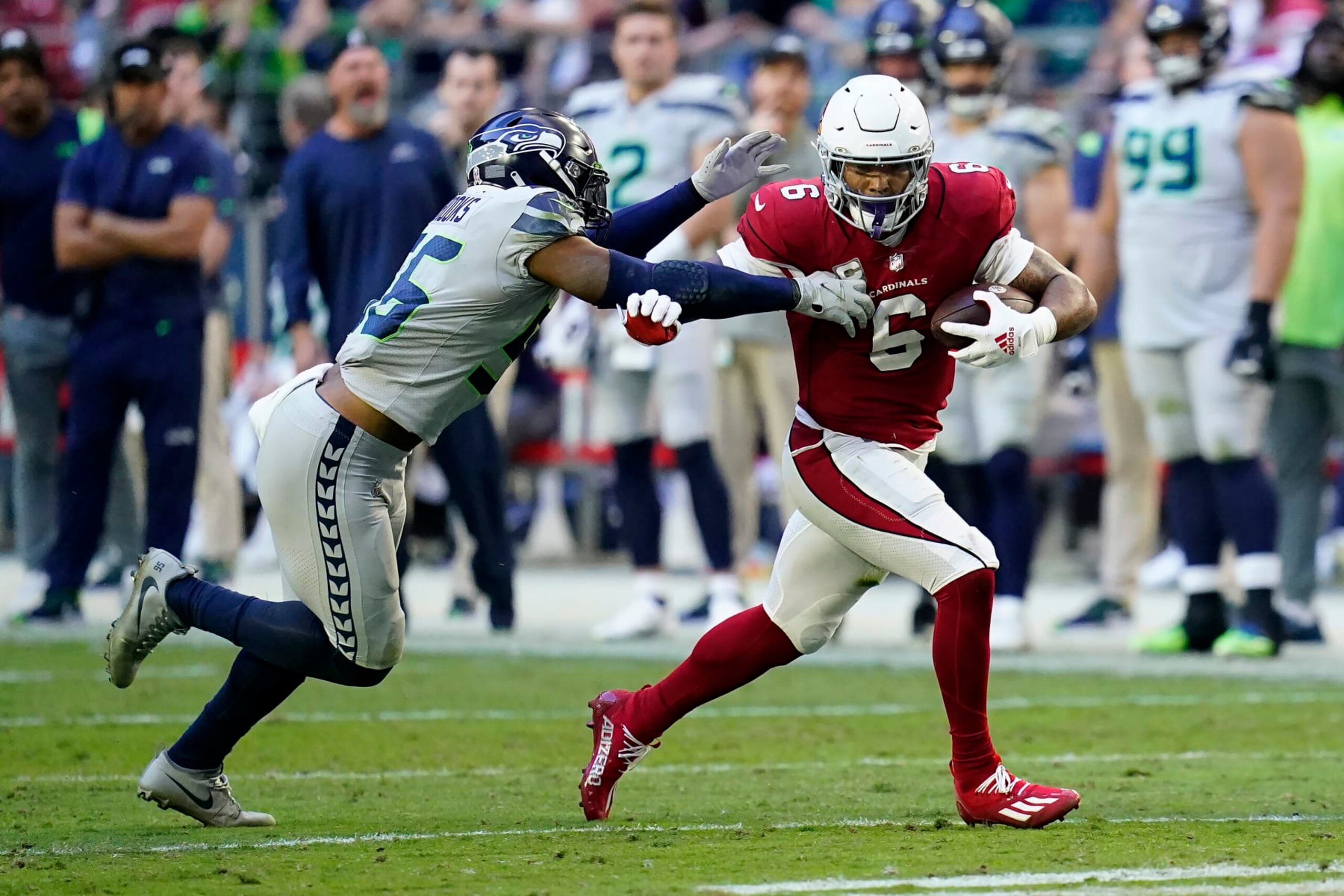Arizona Cardinals running back James Conner (6) runs against Seattle Seahawks linebacker Jordyn Brooks during an NFL football game in Glendale, Ariz., Sunday, Nov. 6, 2022. (AP Photo/Ross D. Franklin)