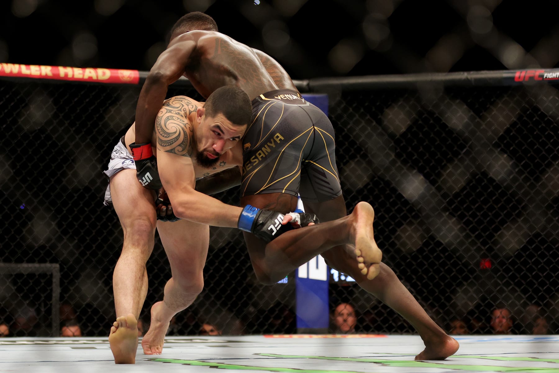 Israel Adesanya defends a takedown attempt in a fight with Robert Whittaker. 