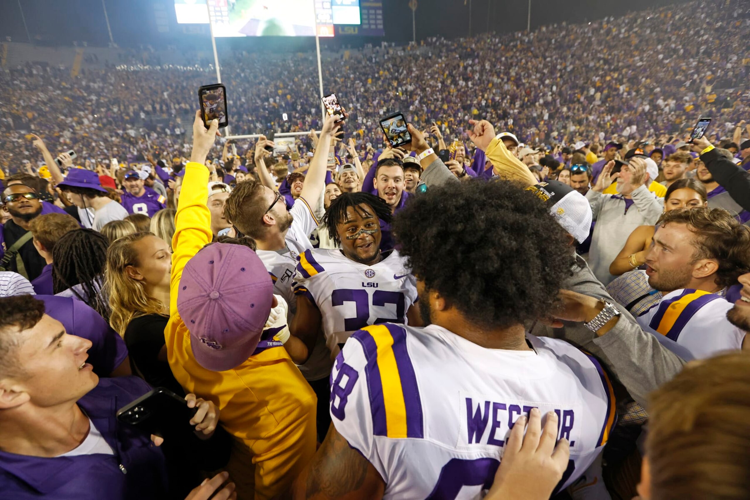 LSU offensive lineman Fitzgerald West Jr. (68) and linebacker DeMario Tolan (32) celebrate with fans who stormed the field after an NCAA college football game against Alabama in Baton Rouge, La., Saturday, Nov. 5, 2022. LSU won 32-31 in overtime. (AP Photo/Tyler Kaufman) LSU offensive lineman Fitzgerald West Jr. (68) and linebacker DeMario Tolan (32) celebrate with fans who stormed the field after an NCAA college football game against Alabama in Baton Rouge, La., Saturday, Nov. 5, 2022. LSU won 32-31 in overtime. (AP Photo/Tyler Kaufman)