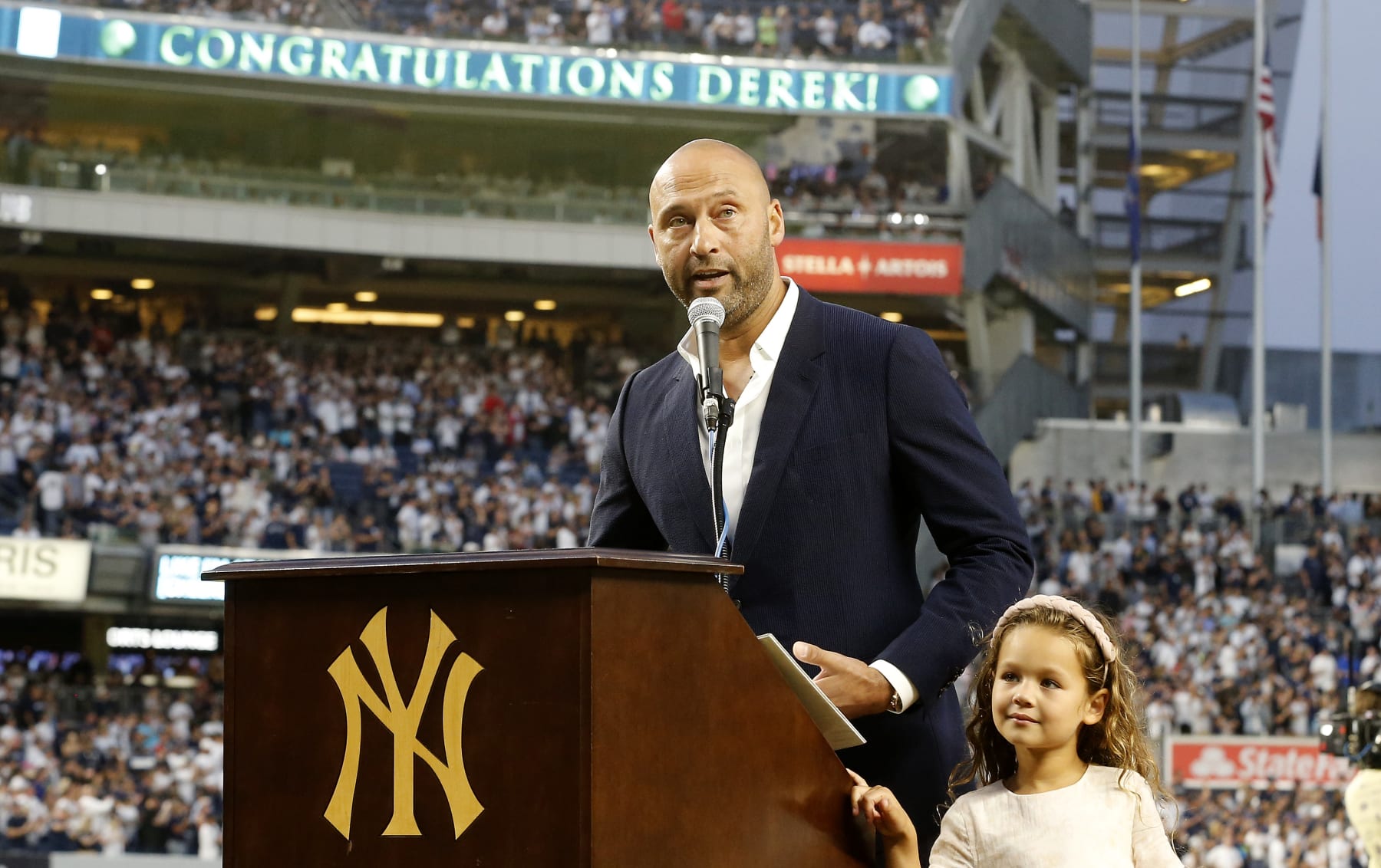 NEW YORK, NEW YORK - SEPTEMBER 09: Baseball Hall of famer Derek Jeter speaks to the fans alongside his daughter Bella as he is honored by the New York Yankees before a game against the Tampa Bay Rays at Yankee Stadium on September 09, 2022 in the Bronx borough of New York City. (Photo by Jim McIsaac/Getty Images)