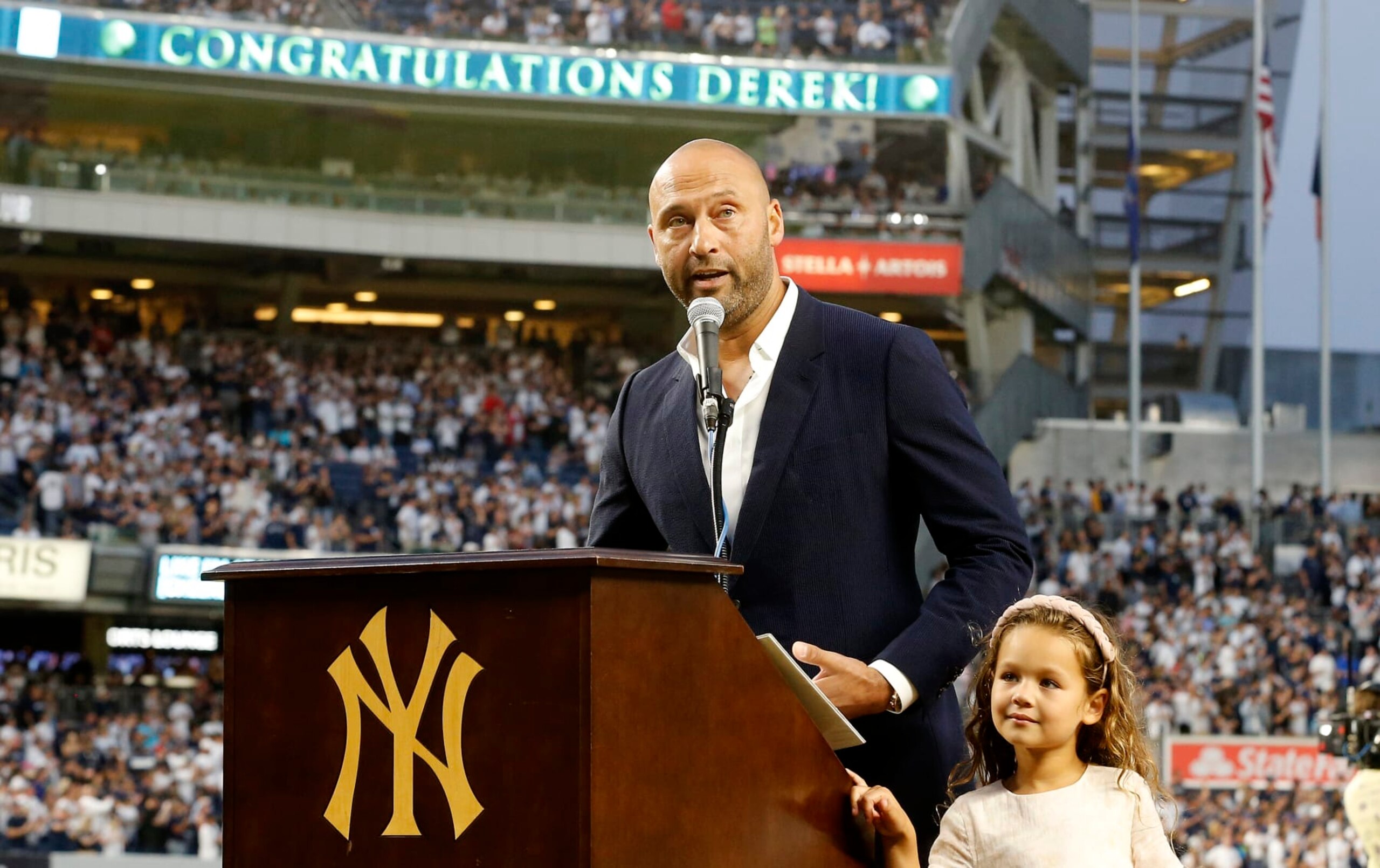 NEW YORK, NEW YORK - SEPTEMBER 09: Baseball Hall of famer Derek Jeter speaks to the fans alongside his daughter Bella as he is honored by the New York Yankees before a game against the Tampa Bay Rays at Yankee Stadium on September 09, 2022 in the Bronx borough of New York City. (Photo by Jim McIsaac/Getty Images)