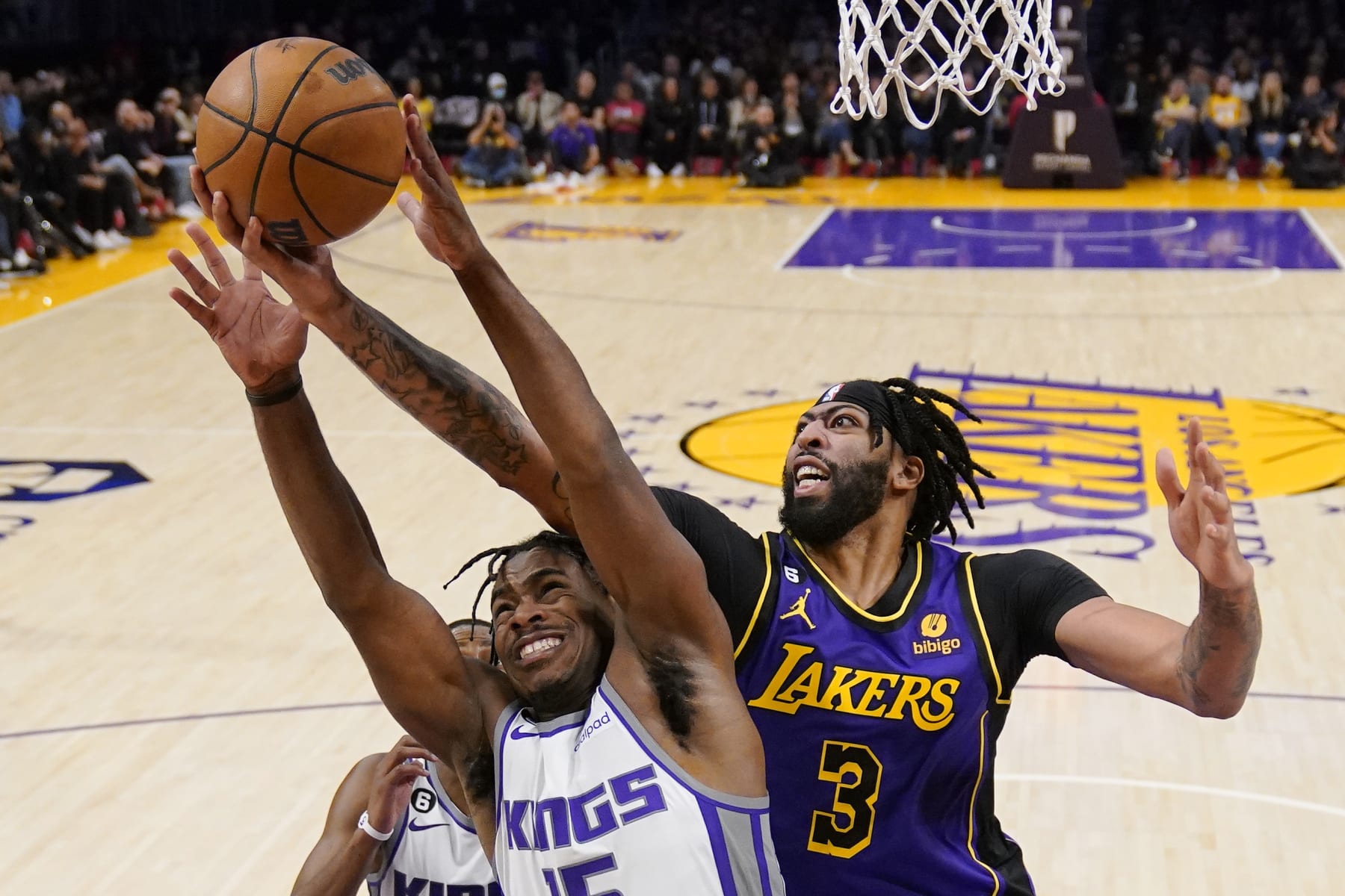 Sacramento Kings guard Davion Mitchell, left, and Los Angeles Lakers forward Anthony Davis go after a rebound during the second half of an NBA basketball game Friday, Nov. 11, 2022, in Los Angeles. (AP Photo/Mark J. Terrill)