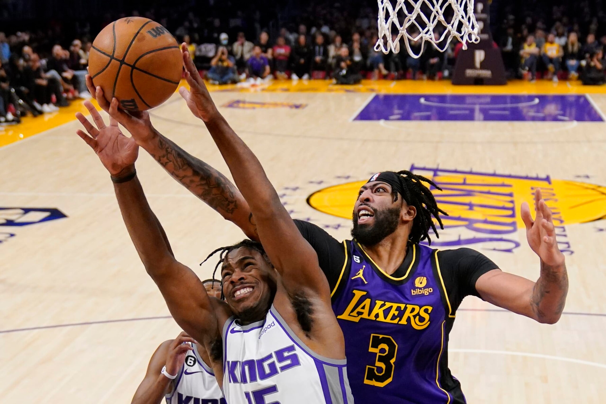 Sacramento Kings guard Davion Mitchell, left, and Los Angeles Lakers forward Anthony Davis go after a rebound during the second half of an NBA basketball game Friday, Nov. 11, 2022, in Los Angeles. (AP Photo/Mark J. Terrill)