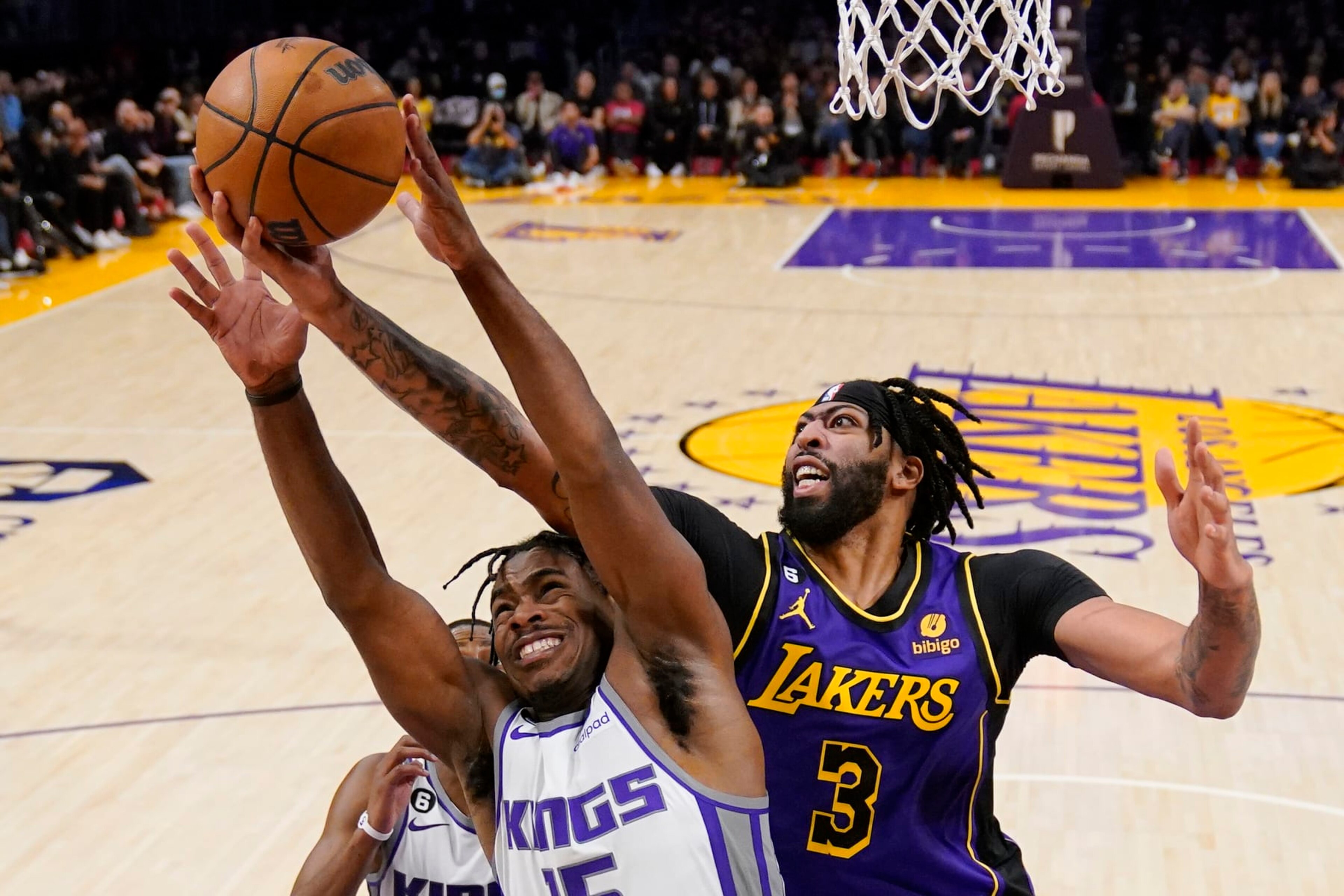 Sacramento Kings guard Davion Mitchell, left, and Los Angeles Lakers forward Anthony Davis go after a rebound during the second half of an NBA basketball game Friday, Nov. 11, 2022, in Los Angeles. (AP Photo/Mark J. Terrill)