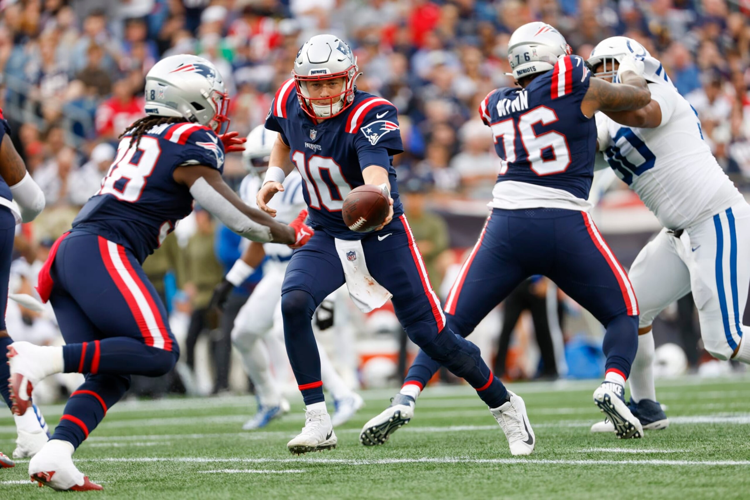 New England Patriots quarterback Mac Jones (10) hands the ball off to running back Rhamondre Stevenson (38) during the second half of an NFL football game, Sunday, Nov. 6, 2022, in Foxborough, Mass. (AP Photo/Greg M. Cooper) New England Patriots quarterback Mac Jones (10) hands the ball off to running back Rhamondre Stevenson (38) during the second half of an NFL football game, Sunday, Nov. 6, 2022, in Foxborough, Mass. (AP Photo/Greg M. Cooper)