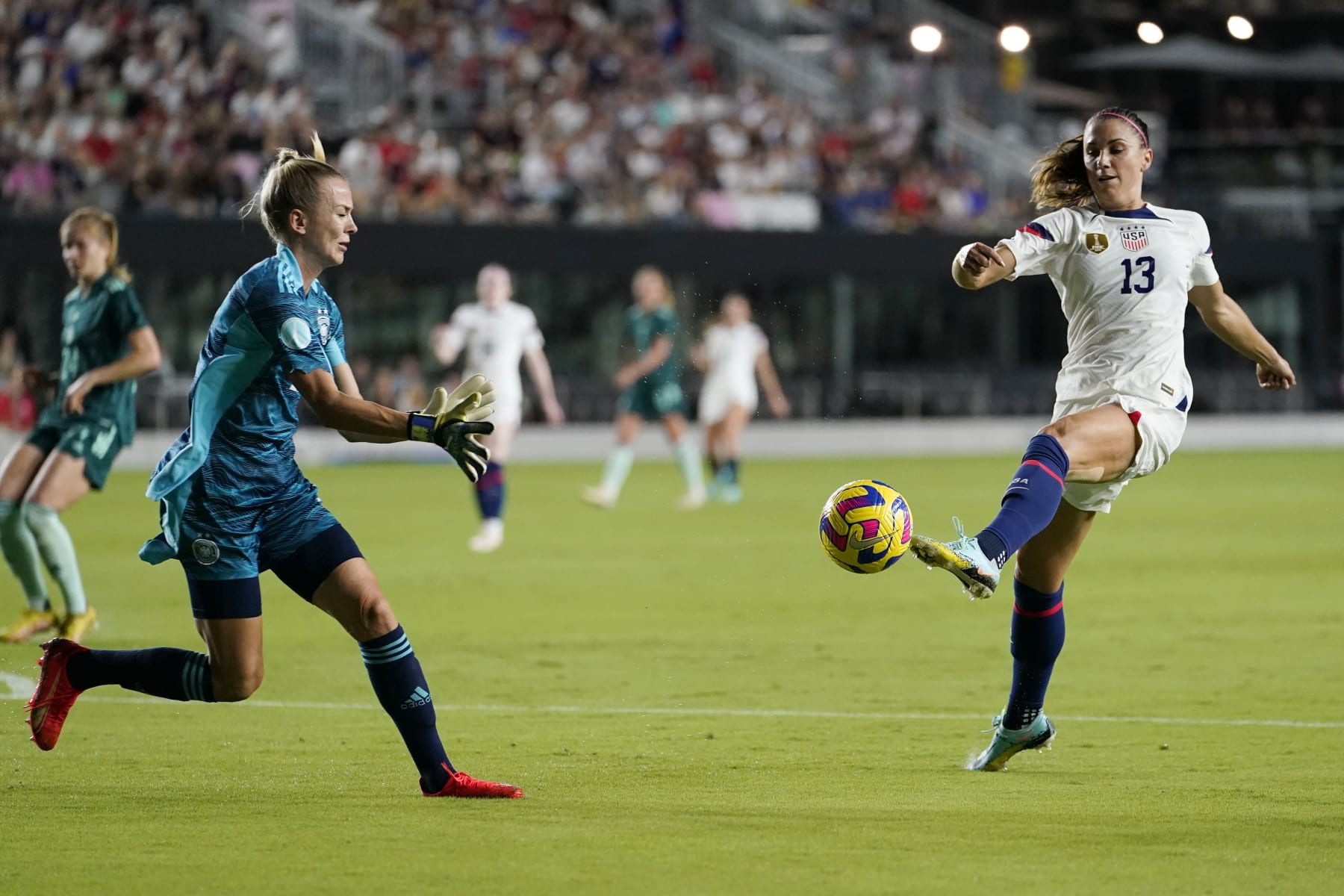 U.S. forward Alex Morgan (13) attempts a shot on the goal as Germany goalkeeper Merle Frohms defends an international friendly soccer match, Thursday, Nov. 10, 2022, in Fort Lauderdale, Fla. (AP Photo/Lynne Sladky)