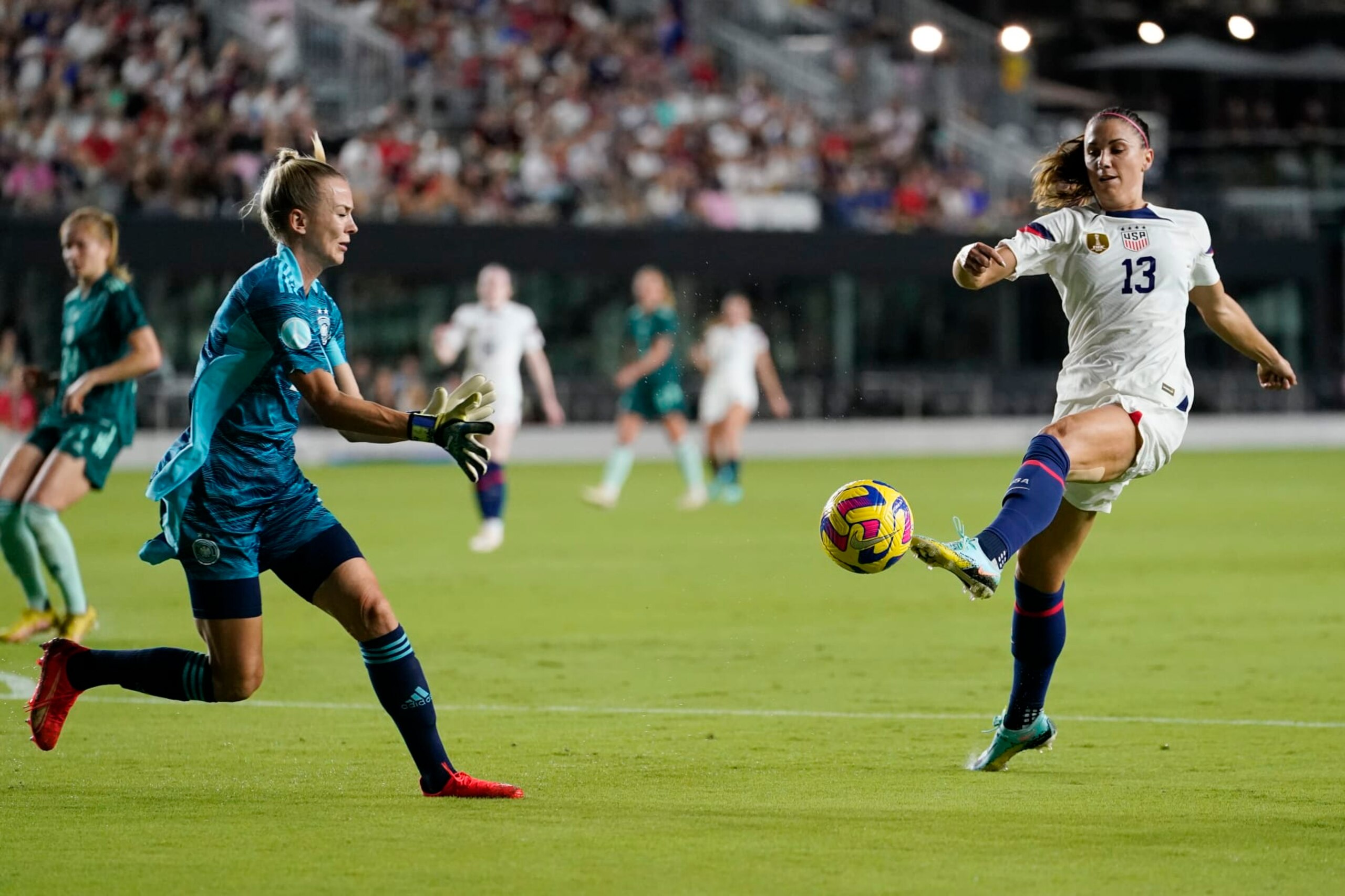 U.S. forward Alex Morgan (13) attempts a shot on the goal as Germany goalkeeper Merle Frohms defends an international friendly soccer match, Thursday, Nov. 10, 2022, in Fort Lauderdale, Fla. (AP Photo/Lynne Sladky)