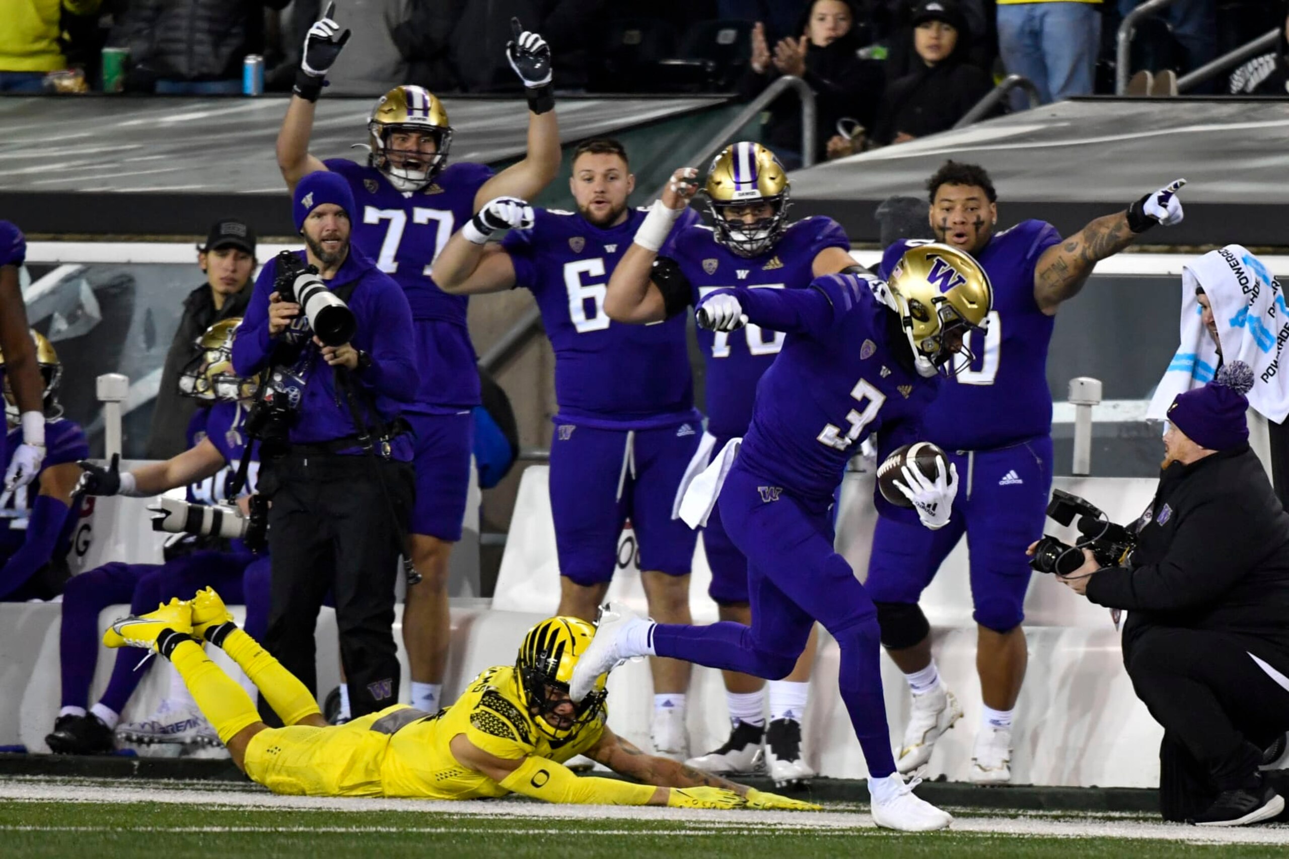 Washington wide receiver Taj Davis (3) eludes a tackle by Oregon defensive back Bennett Williams, bottom left, and heads to the end zone as teammates point the way during the second half of an NCAA college football game Saturday, Nov. 12, 2022, in Eugene, Ore. (AP Photo/Andy Nelson)