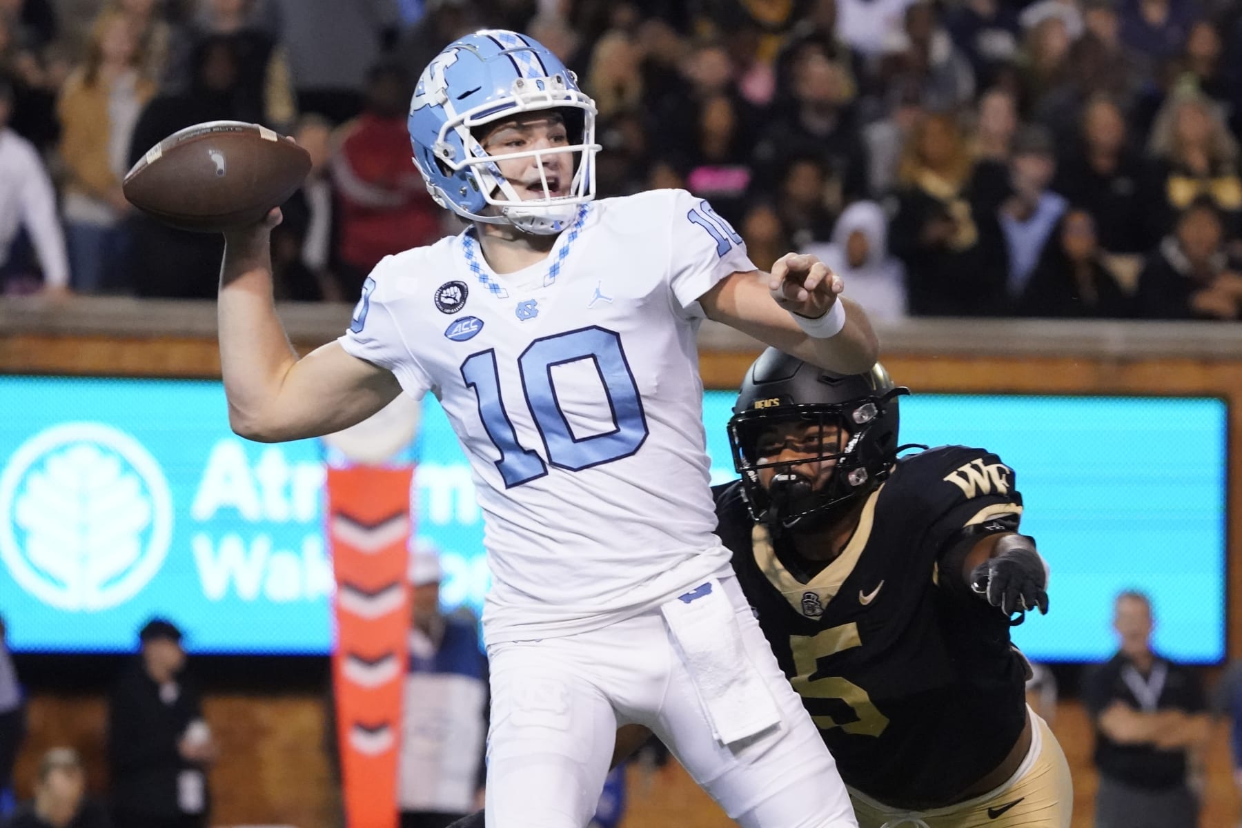 North Carolina quarterback Drake Maye (10) looks to pass as Wake Forest linebacker Ryan Smenda Jr. (5 ) runs towards him during the first half of an NCAA college football game in Winston-Salem, N.C., Saturday, Nov. 12, 2022. (AP Photo/Chuck Burton)