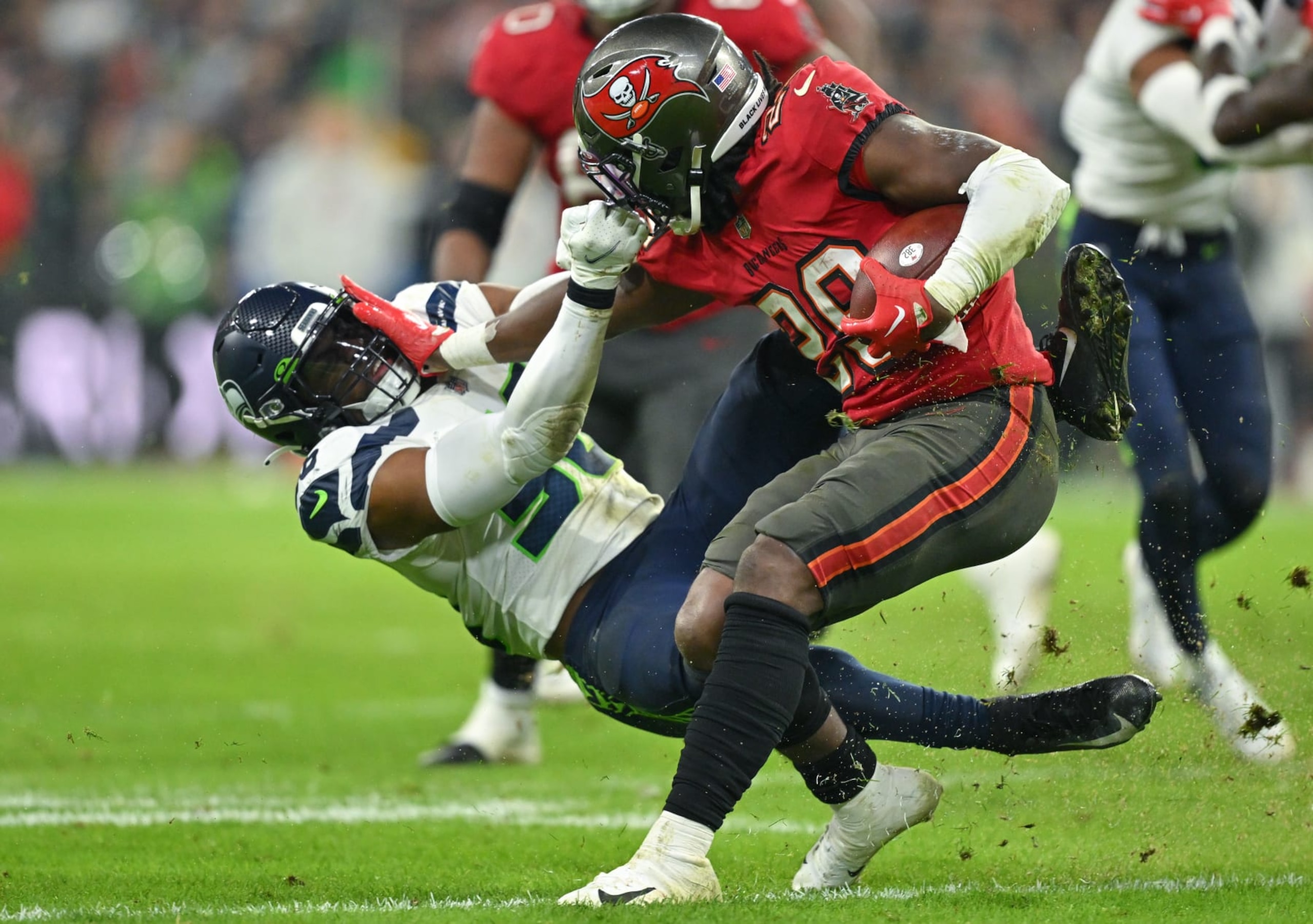 MUNICH, GERMANY - NOVEMBER 13: Jordyn Brooks #56 of the Seattle Seahawks is fended off by Rachaad White #29 of the Tampa Bay Buccaneers in the third quarter during the NFL match between Seattle Seahawksย and Tampa Bay Buccaneers at Allianz Arena on November 13, 2022 in Munich, Germany. (Photo by Sebastian Widmann/Getty Images) MUNICH, GERMANY - NOVEMBER 13: Jordyn Brooks #56 of the Seattle Seahawks is fended off by Rachaad White #29 of the Tampa Bay Buccaneers in the third quarter during the NFL match between Seattle Seahawksย and Tampa Bay Buccaneers at Allianz Arena on November 13, 2022 in Munich, Germany. (Photo by Sebastian Widmann/Getty Images)