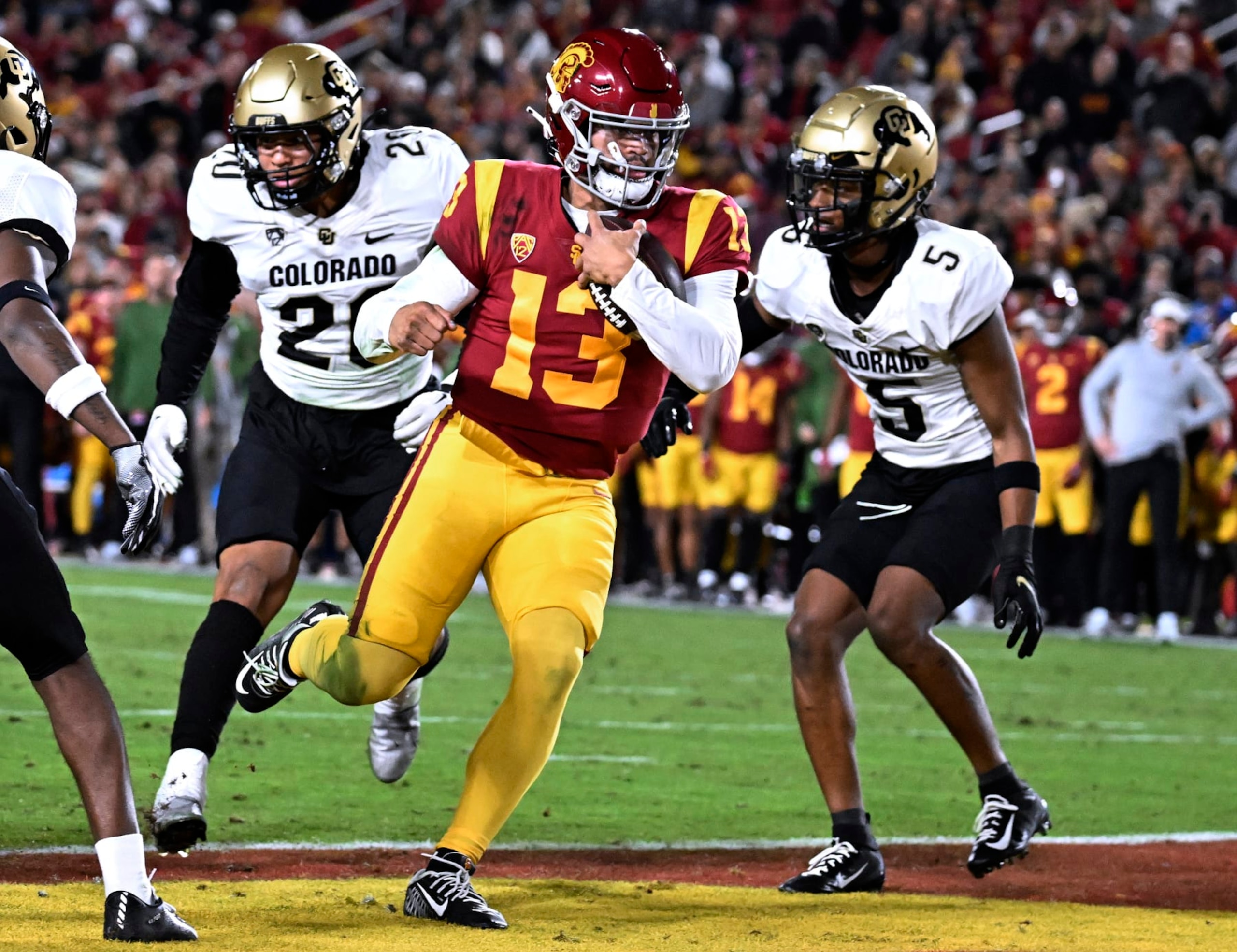 Southern California quarterback Caleb Williams scores a touchdown, getting past Colorado's Robert Barnes, left, and Tyrin Taylor during the first half of an NCAA college football game Friday, Nov. 11, 2022, in Los Angeles. (AP Photo/John McCoy)