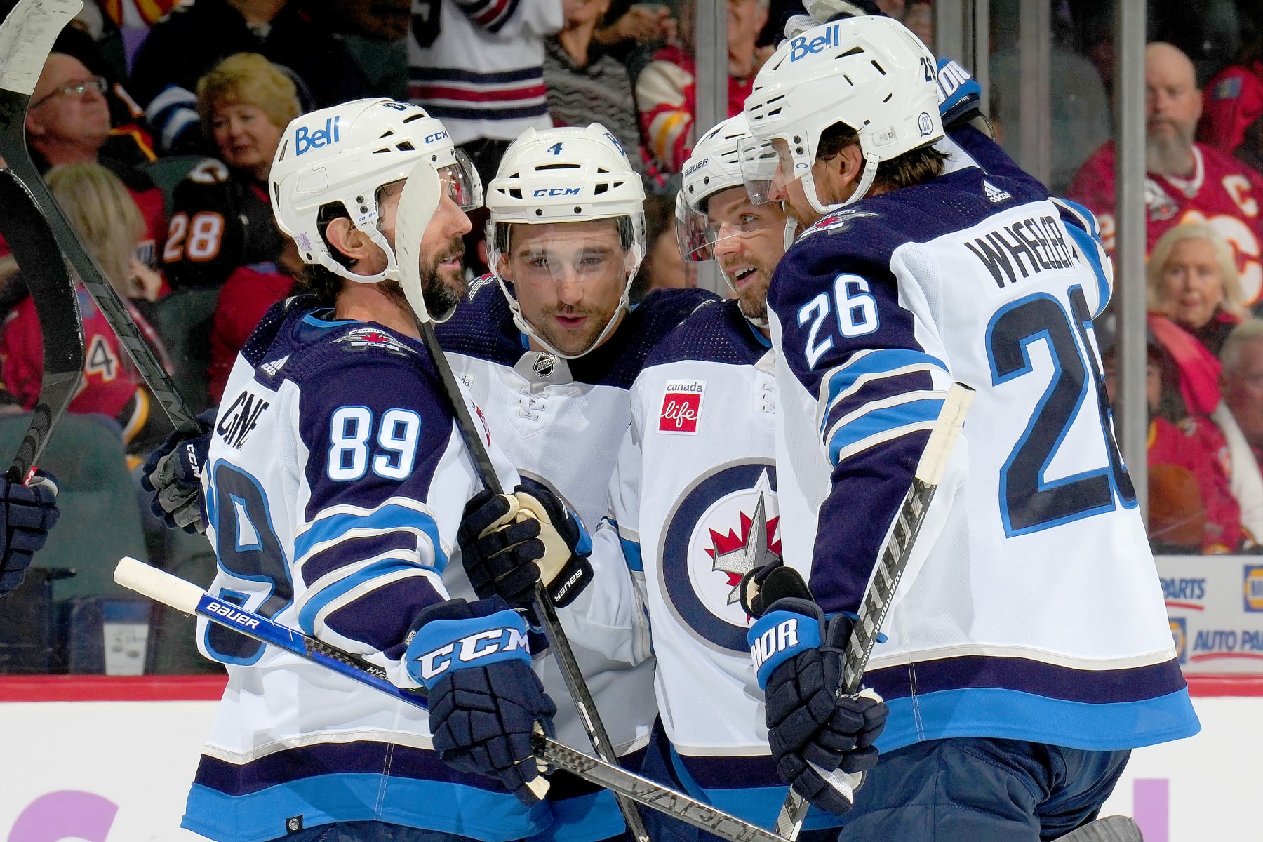 CALGARY, ALBERTA - NOVEMBER 12: Sam Gagner #89, Blake Wheeler #26 and teammates of the Winnipeg Jets celebrate a goal against the Calgary Flames at Scotiabank Saddledome on November 12, 2022 in Calgary, Alberta. (Photo by Gerry Thomas/NHLI via Getty Images)
