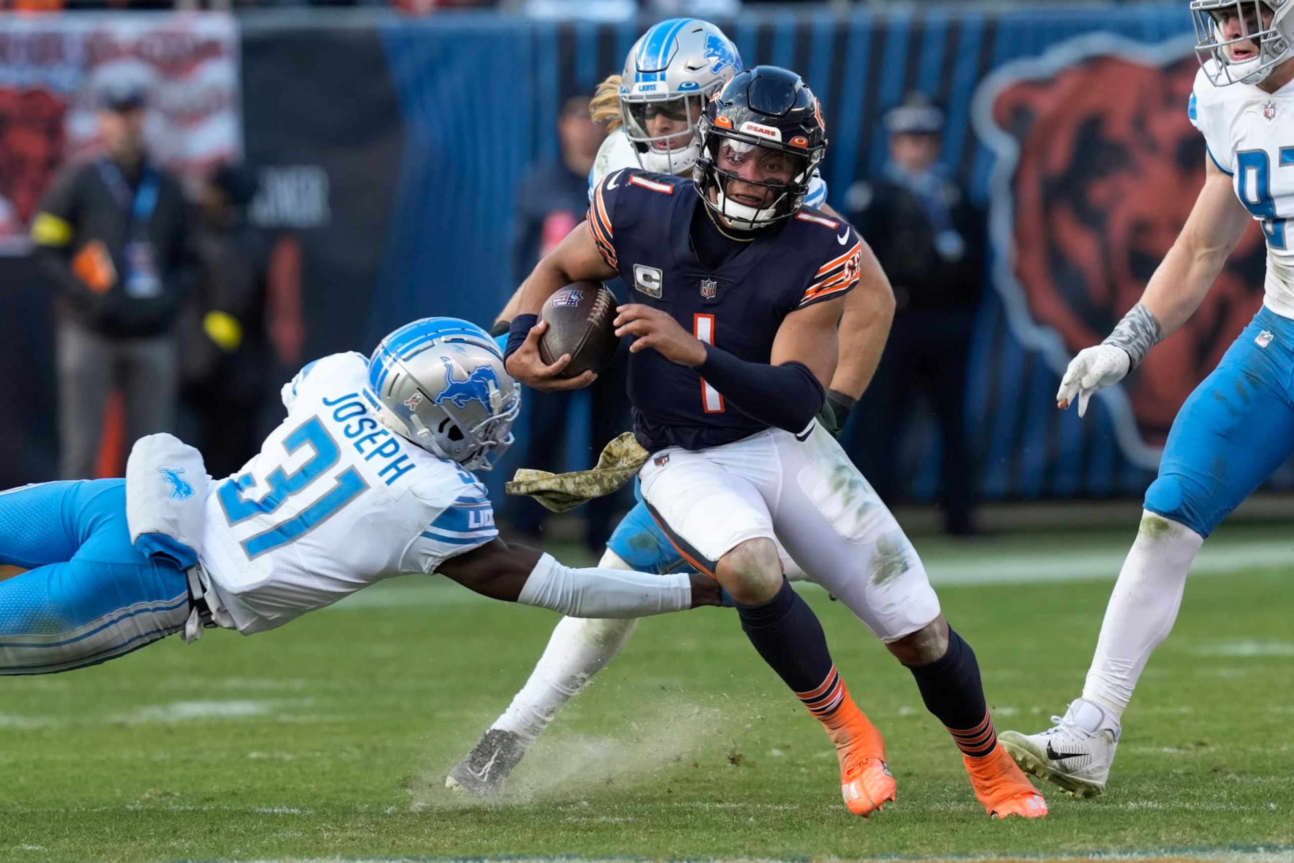 Chicago Bears quarterback Justin Fields (1) evades Detroit Lions safety Kerby Joseph (31) running for a 67-yard touchdown during the second half of an NFL football game in Chicago, Sunday, Nov. 13, 2022. (AP Photo/Charles Rex Arbogast) Chicago Bears quarterback Justin Fields (1) evades Detroit Lions safety Kerby Joseph (31) running for a 67-yard touchdown during the second half of an NFL football game in Chicago, Sunday, Nov. 13, 2022. (AP Photo/Charles Rex Arbogast)