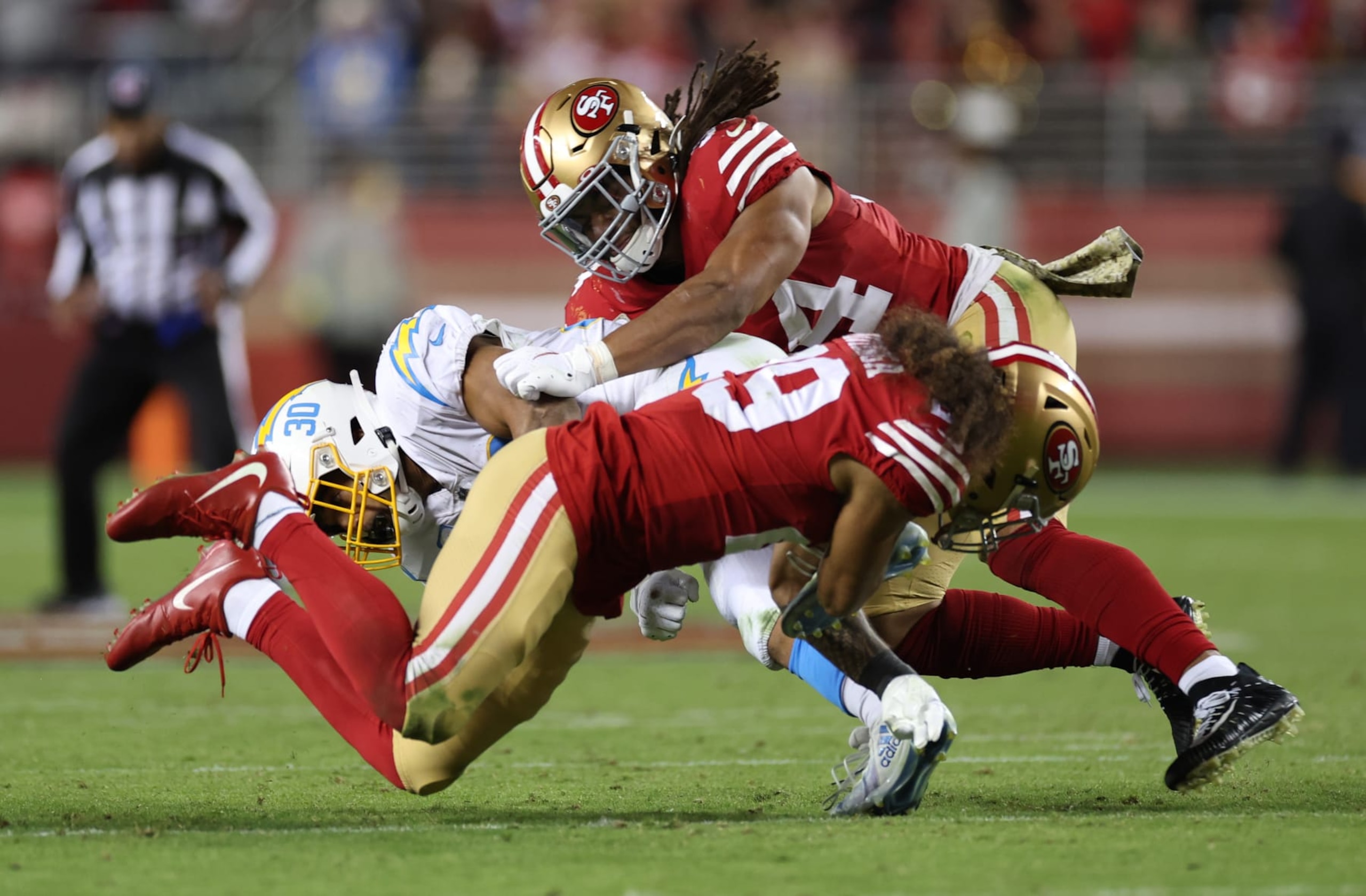 SANTA CLARA, CALIFORNIA - NOVEMBER 13: Talanoa Hufanga #29 and Fred Warner #54 of the San Francisco 49ers tackle Austin Ekeler #30 of the Los Angeles Chargers during the fourth quarter at Levi's Stadium on November 13, 2022 in Santa Clara, California. (Photo by Ezra Shaw/Getty Images) SANTA CLARA, CALIFORNIA - NOVEMBER 13: Talanoa Hufanga #29 and Fred Warner #54 of the San Francisco 49ers tackle Austin Ekeler #30 of the Los Angeles Chargers during the fourth quarter at Levi's Stadium on November 13, 2022 in Santa Clara, California. (Photo by Ezra Shaw/Getty Images)