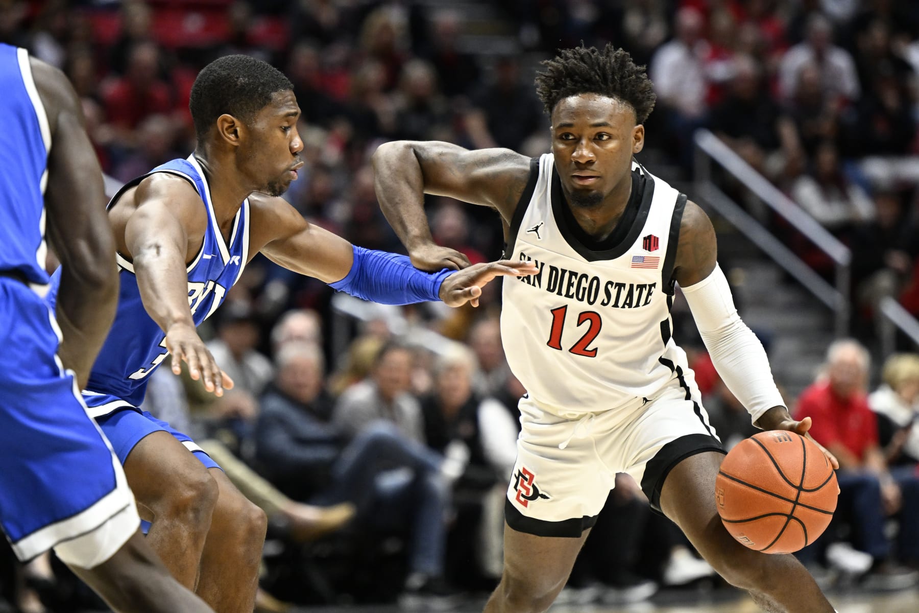 San Diego State guard Darrion Trammell (12) drives past BYU guard Rudi Williams (3) during the first half of an NCAA college basketball game Friday, Nov. 11, 2022, in San Diego. (AP Photo/Denis Poroy)