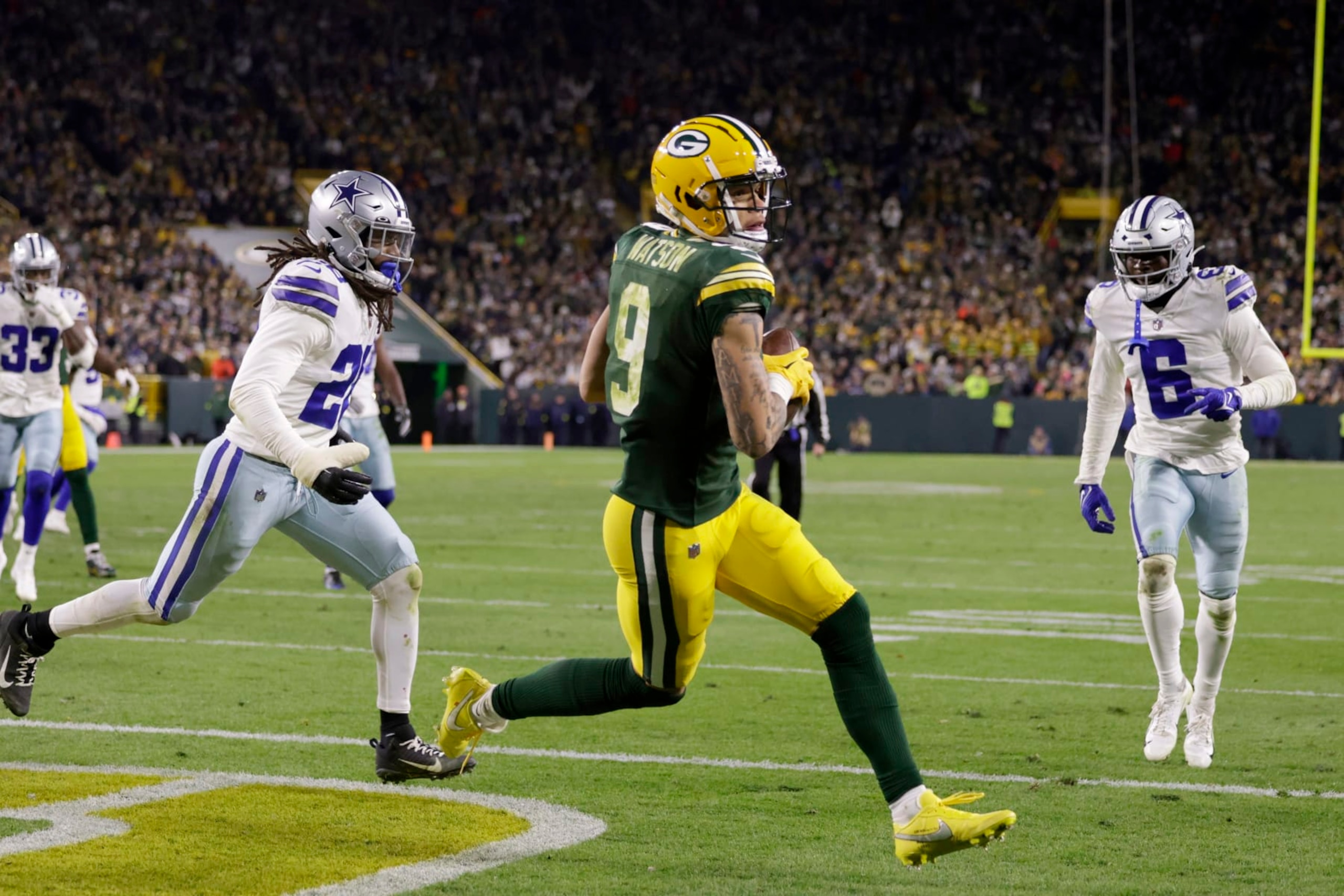 Green Bay Packers wide receiver Christian Watson (9) catches a touchdown pass between Dallas Cowboys' Malik Hooker, left, and Donovan Wilson (6) during the second half of an NFL football game Sunday, Nov. 13, 2022, in Green Bay, Wis. (AP Photo/Matt Ludtke)