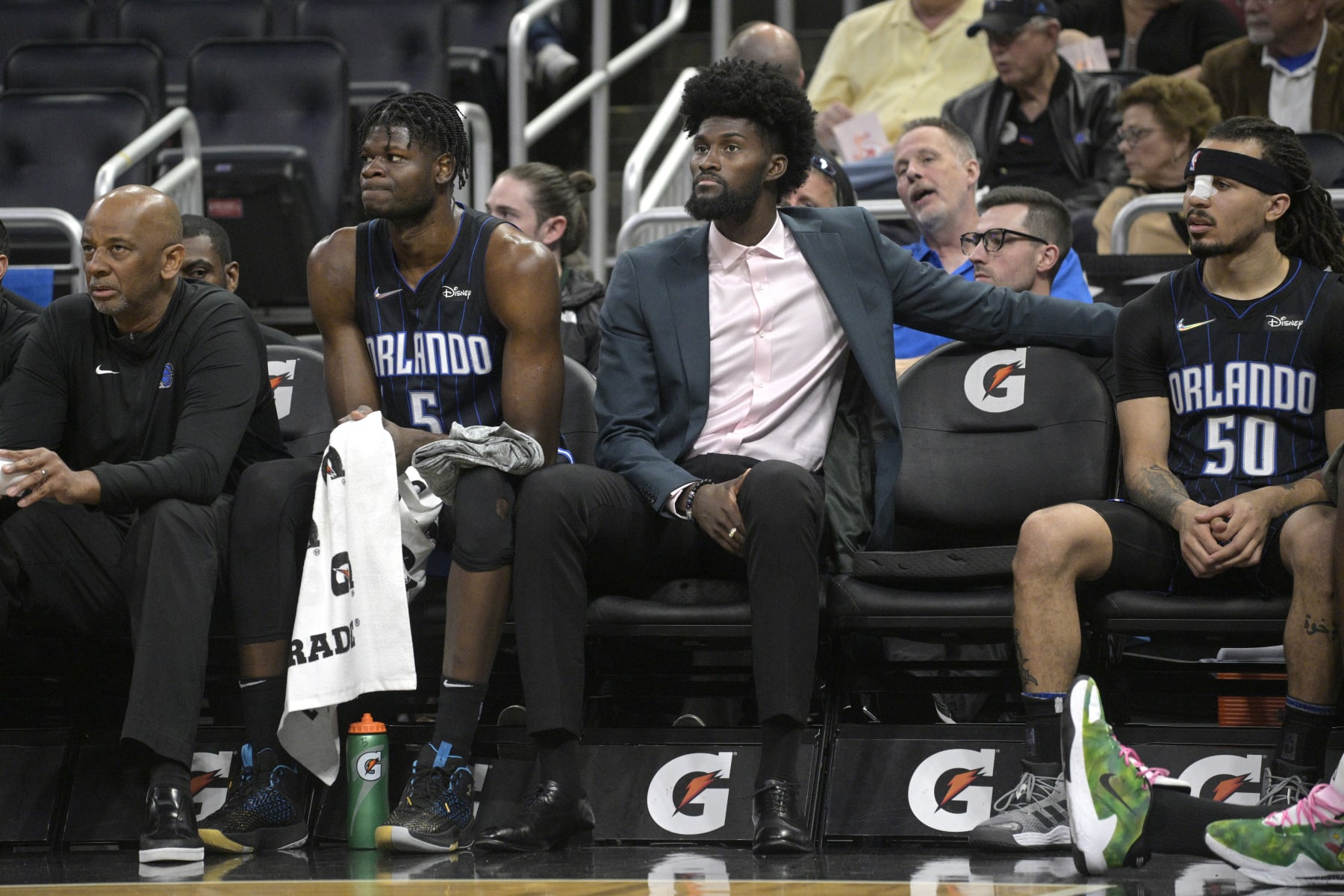 FILE - Orlando Magic forward Jonathan Isaac watches from the bench between center Mo Bamba (5) and guard Cole Anthony (50) during the first half of an NBA basketball game against the Philadelphia 76ers, Sunday, March 13, 2022, in Orlando, Fla. The Orlando Magic announced Tuesday, March 15, 2022, that Jonathan Isaac, who has missed the last two years with a knee injury, will not return this season.(AP Photo/Phelan M. Ebenhack, File)
