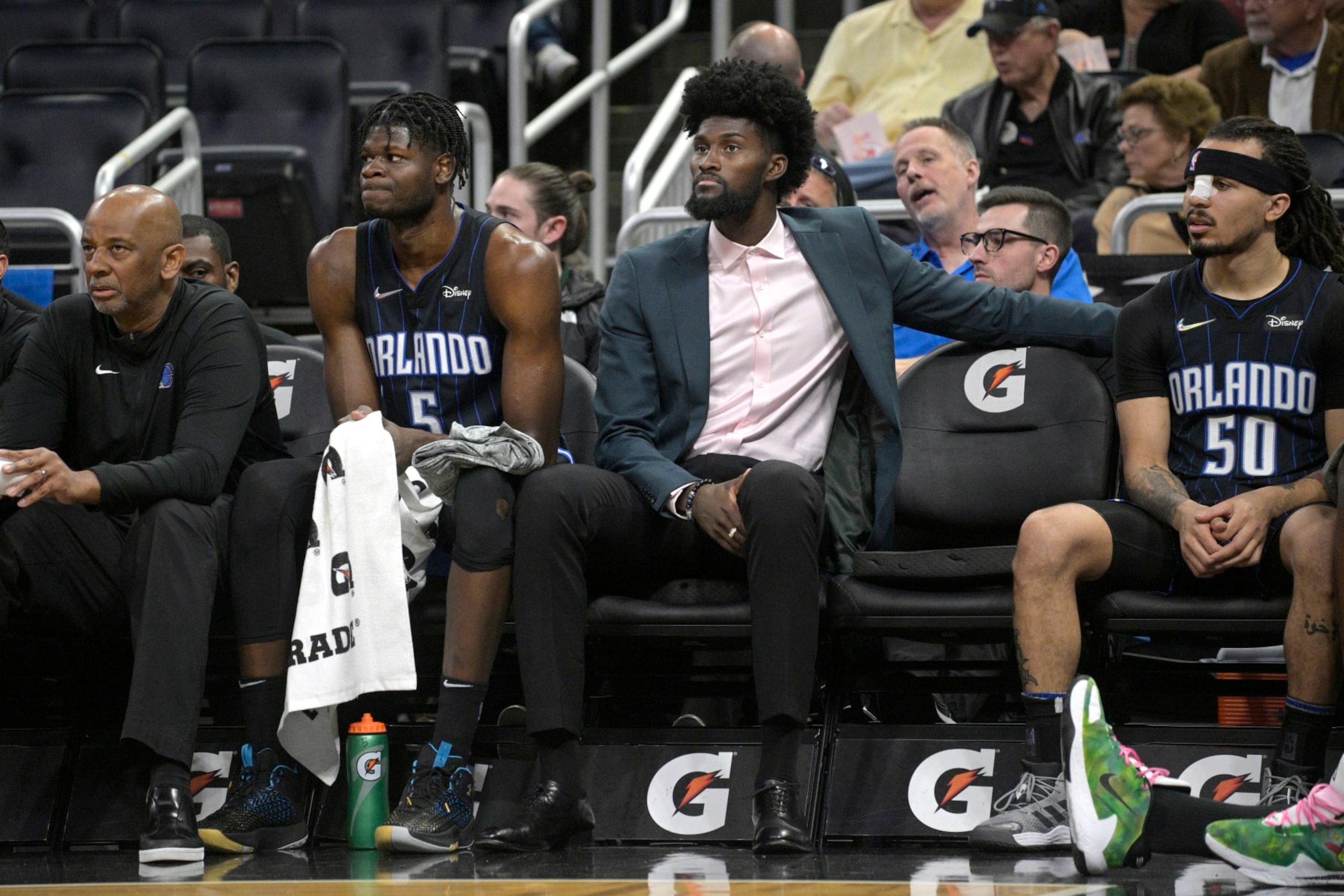 FILE - Orlando Magic forward Jonathan Isaac watches from the bench between center Mo Bamba (5) and guard Cole Anthony (50) during the first half of an NBA basketball game against the Philadelphia 76ers, Sunday, March 13, 2022, in Orlando, Fla. The Orlando Magic announced Tuesday, March 15, 2022, that Jonathan Isaac, who has missed the last two years with a knee injury, will not return this season.(AP Photo/Phelan M. Ebenhack, File) FILE - Orlando Magic forward Jonathan Isaac watches from the bench between center Mo Bamba (5) and guard Cole Anthony (50) during the first half of an NBA basketball game against the Philadelphia 76ers, Sunday, March 13, 2022, in Orlando, Fla. The Orlando Magic announced Tuesday, March 15, 2022, that Jonathan Isaac, who has missed the last two years with a knee injury, will not return this season.(AP Photo/Phelan M. Ebenhack, File)