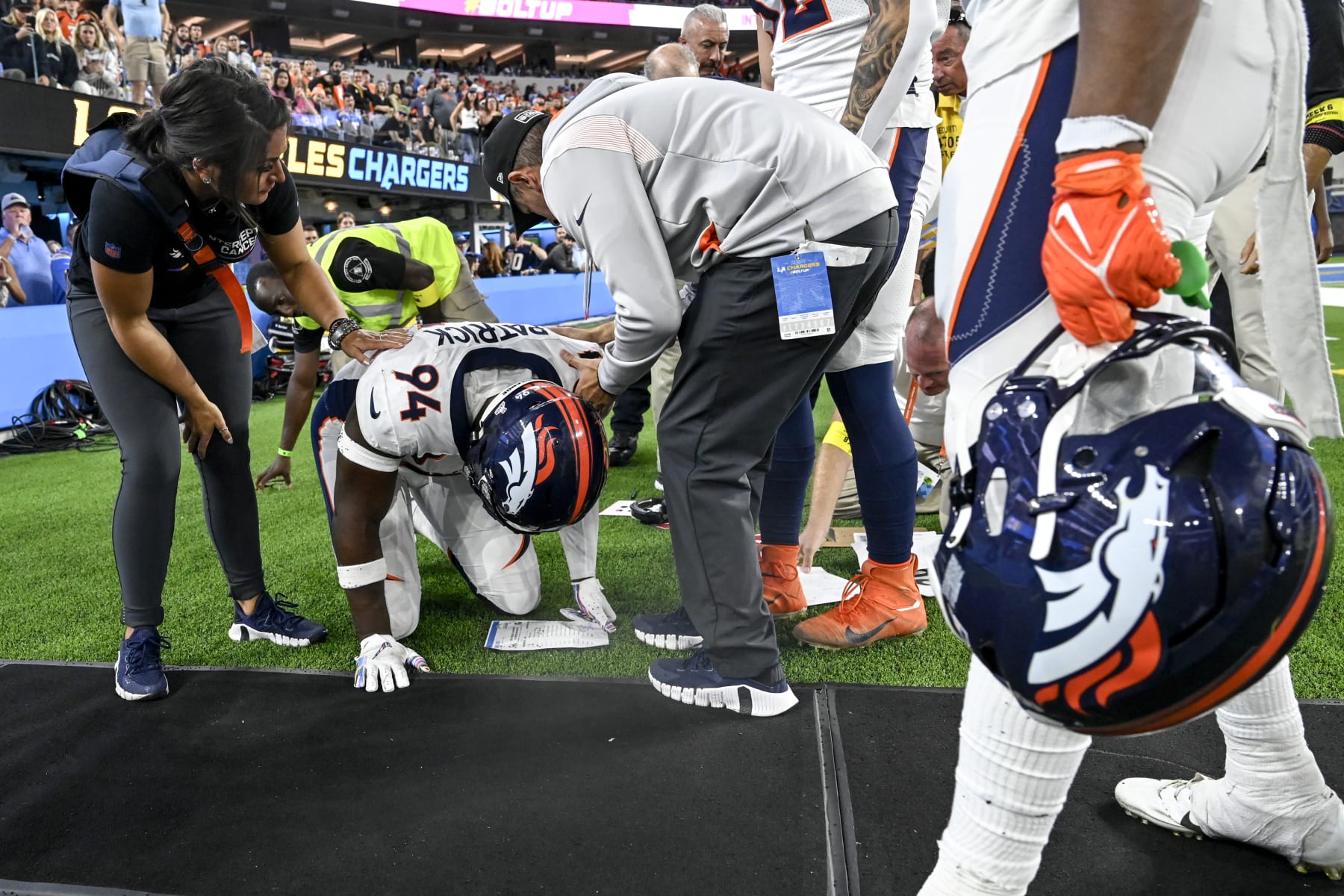 INGLEWOOD , CA - OCTOBER 17: Aaron Patrick (94) of the Denver Broncos kneels on the ground after colliding with a middle aged sideline worker during overtime of the Los Angeles Chargers 19-16 win at SoFi Stadium in Inglewood, California on Monday, October 17, 2022. The worker was quick to return to his post as team medical personnel tended to Patrick. (Photo by AAron Ontiveroz/MediaNews Group/The Denver Post via Getty Images)