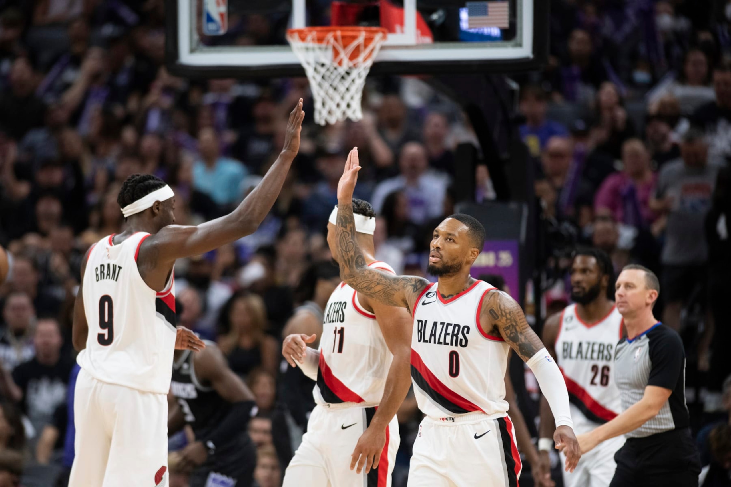 Portland Trail Blazers guard Damian Lillard (0) and forward Jerami Grant (9) celebrate late in the team's NBA basketball game against the Sacramento Kings in Sacramento, Calif., Wednesday, Oct. 19, 2022. The Trail Blazers won 115-108. (AP Photo/José Luis Villegas)