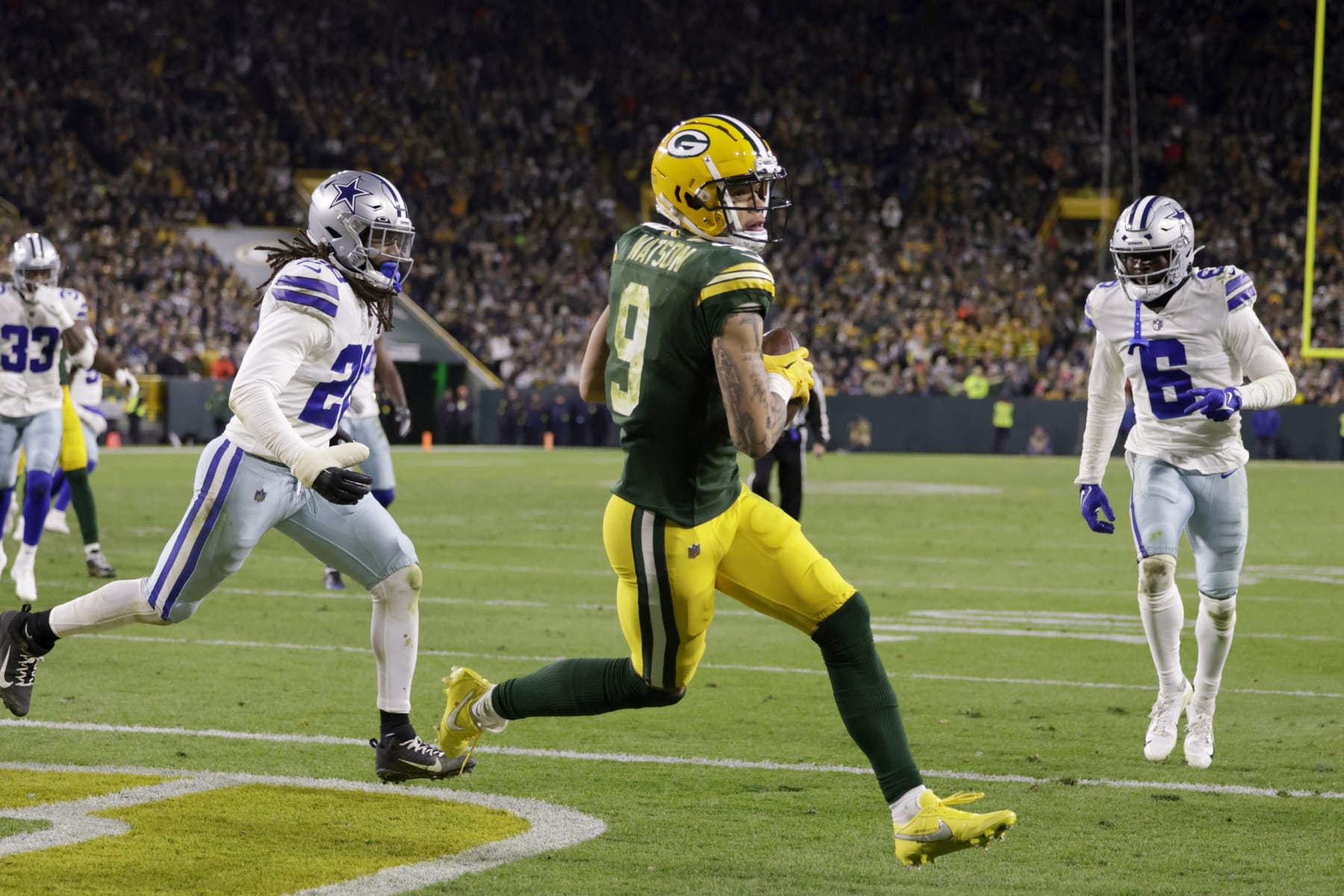 Green Bay Packers wide receiver Christian Watson (9) catches a touchdown pass between Dallas Cowboys' Malik Hooker, left, and Donovan Wilson (6) during the second half of an NFL football game Sunday, Nov. 13, 2022, in Green Bay, Wis. (AP Photo/Matt Ludtke)