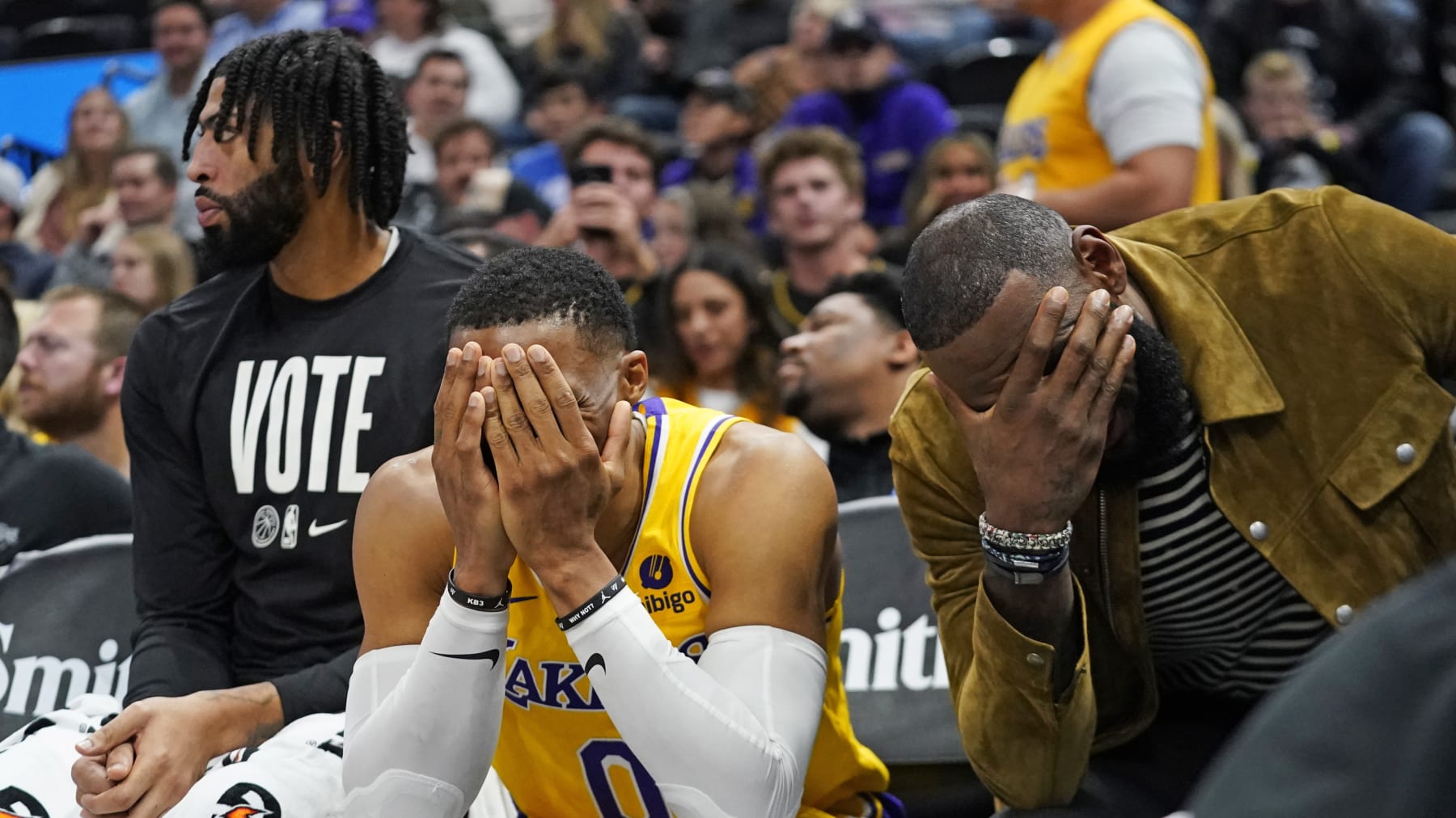 Los Angeles Lakers' Anthony Davis, left, Russell Westbrook (0) and LeBron James sit on the bench near the end of the fourth quarter of the team's NBA basketball game against the Utah Jazz on Monday, Nov. 7, 2022, in Salt Lake City. (AP Photo/Rick Bowmer)