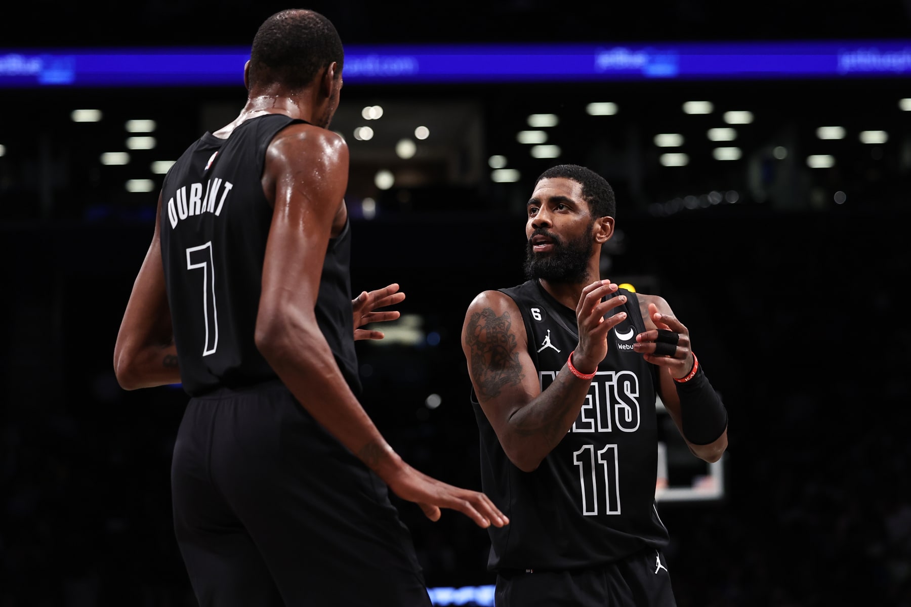 NEW YORK, NEW YORK - OCTOBER 31: Kyrie Irving #11 speaks with Kevin Durant #7 of the Brooklyn Nets during the second quarter of the game against the Indiana Pacers at Barclays Center on October 31, 2022 in New York City. NOTE TO USER: User expressly acknowledges and agrees that, by downloading and or using this photograph, User is consenting to the terms and conditions of the Getty Images License Agreement. (Photo by Dustin Satloff/Getty Images)