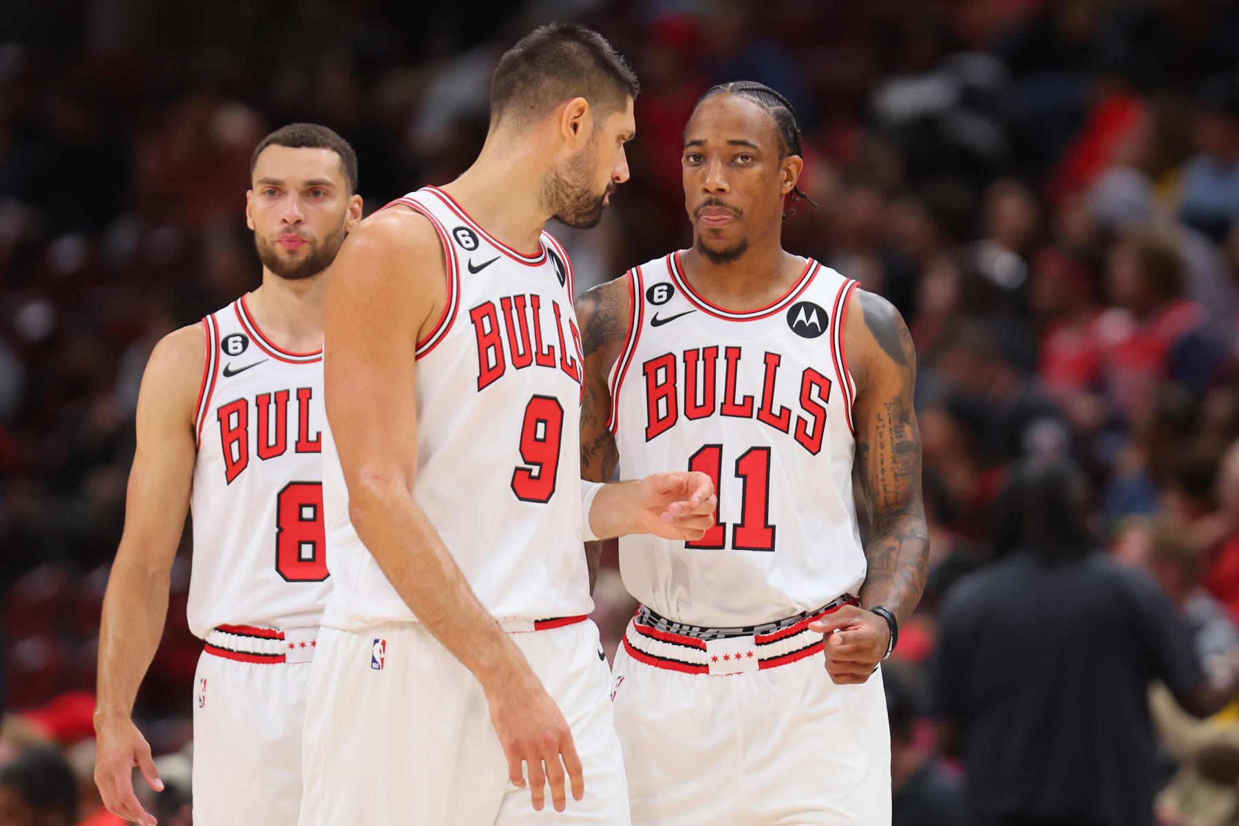 CHICAGO, ILLINOIS - OCTOBER 04: Zach LaVine #8, Nikola Vucevic #9 and DeMar DeRozan #11 of the Chicago Bulls look on against the New Orleans Pelicans during the first half of a preseason game at the United Center on October 04, 2022 in Chicago, Illinois.NOTE TO USER: User expressly acknowledges and agrees that, by downloading and or using this photograph, User is consenting to the terms and conditions of the Getty Images License Agreement. (Photo by Michael Reaves/Getty Images)