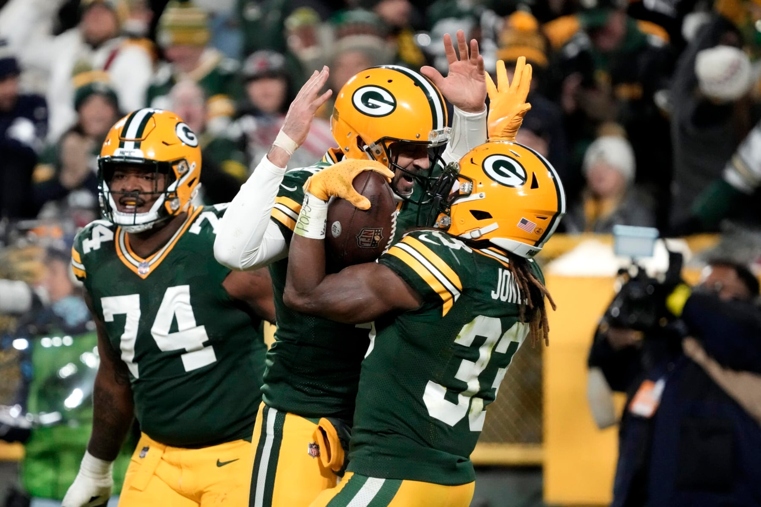 Green Bay Packers quarterback Aaron Rodgers, center left, and Aaron Jones (33), celebrate after Jones scored a touchdown during the first half of an NFL football game against the Dallas Cowboys Sunday, Nov. 13, 2022, in Green Bay, Wis. (AP Photo/Morry Gash)