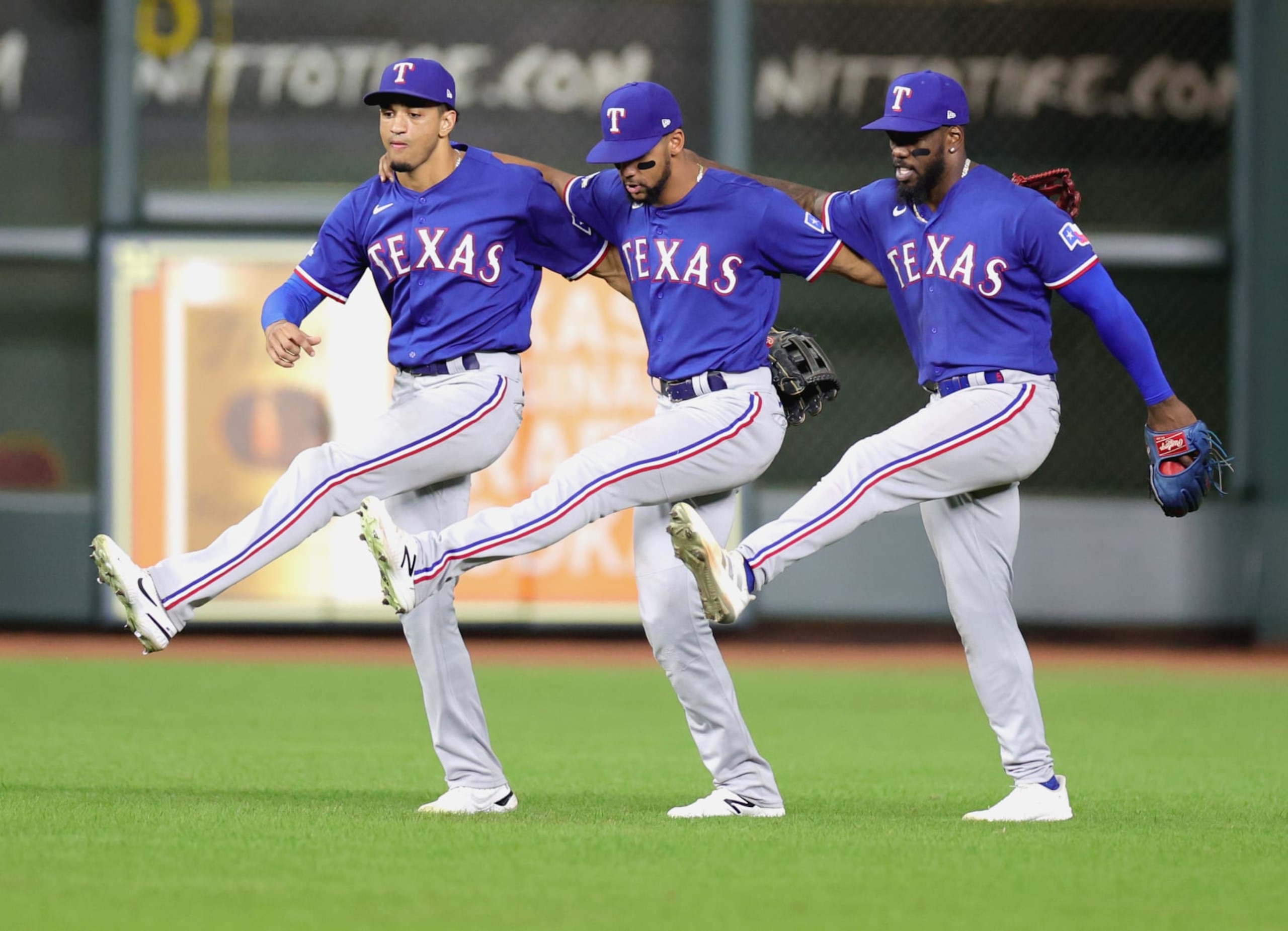HOUSTON, TEXAS - SEPTEMBER 06: Leody Taveras #3, Adolis Garcia #53, and Bubba Thompson #65 of the Texas Rangers celebrate their 4-3 win over the Houston Astros at Minute Maid Park on September 06, 2022 in Houston, Texas. (Photo by Carmen Mandato/Getty Images)