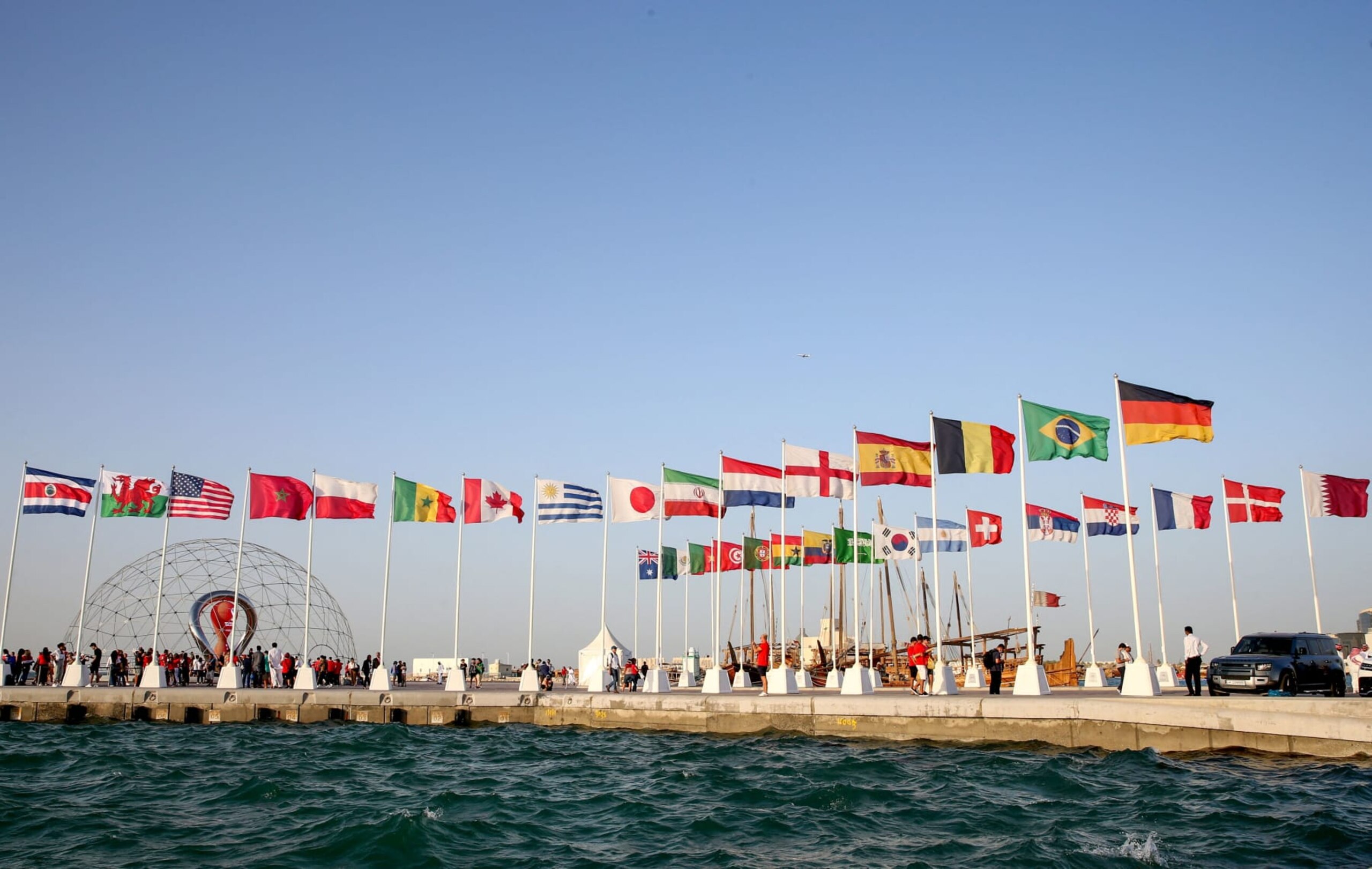 A general view shows flags of the qualified countries for the 2022 World Cup in the Qatari capital Doha during a flag-raising ceremony of the last remaining countries to qualify, on June 16, 2022. (Photo by Mustafa ABUMUNES / AFP) (Photo by MUSTAFA ABUMUNES/AFP via Getty Images) A general view shows flags of the qualified countries for the 2022 World Cup in the Qatari capital Doha during a flag-raising ceremony of the last remaining countries to qualify, on June 16, 2022. (Photo by Mustafa ABUMUNES / AFP) (Photo by MUSTAFA ABUMUNES/AFP via Getty Images)