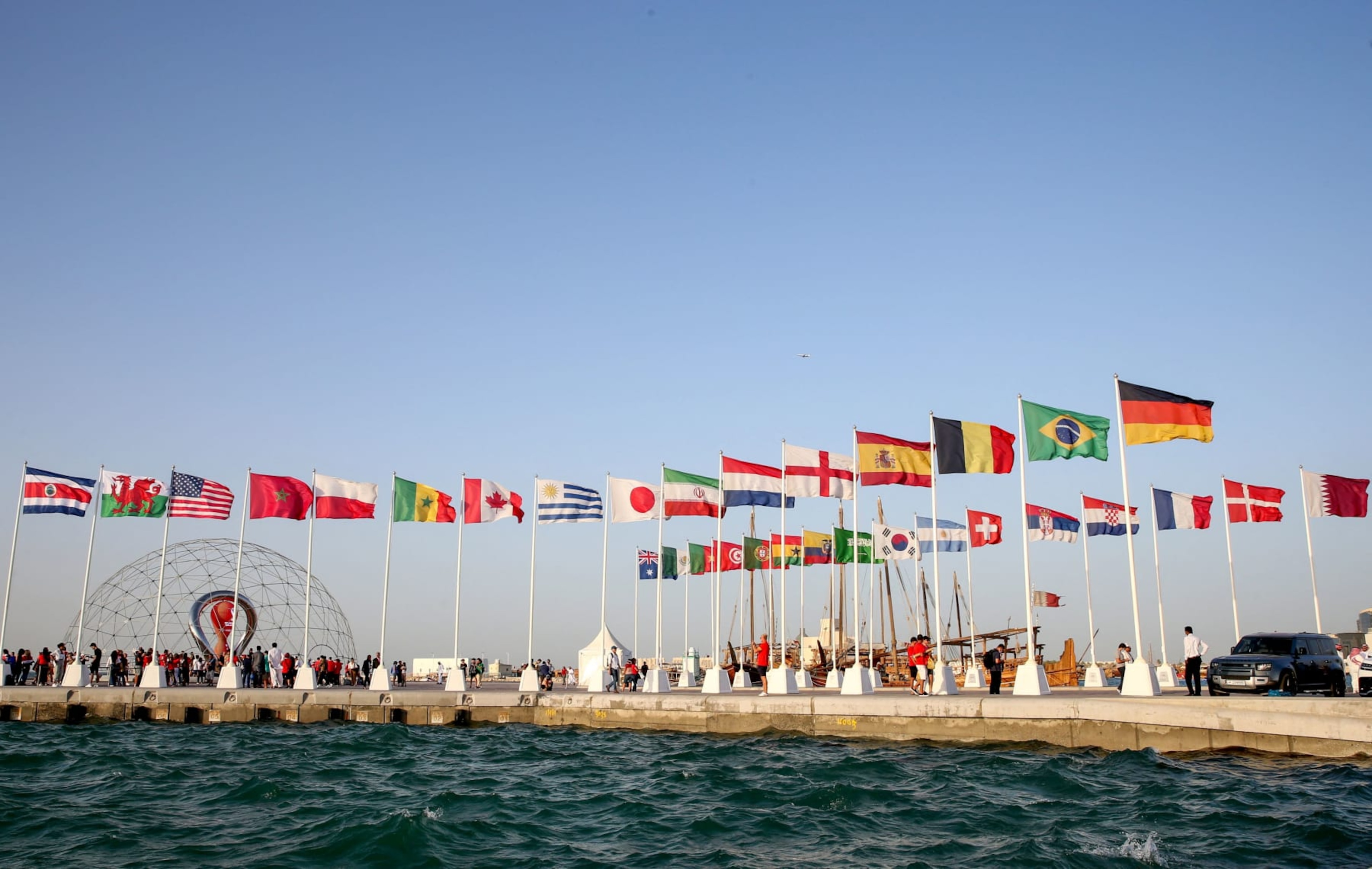 A general view shows flags of the qualified countries for the 2022 World Cup in the Qatari capital Doha during a flag-raising ceremony of the last remaining countries to qualify, on June 16, 2022. (Photo by Mustafa ABUMUNES / AFP) (Photo by MUSTAFA ABUMUNES/AFP via Getty Images)