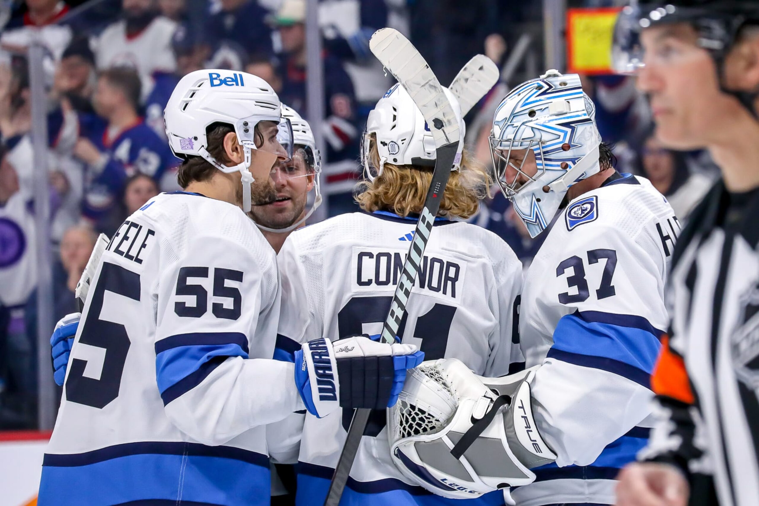 WINNIPEG, CANADA - NOVEMBER 17: Mark Scheifele #55, Josh Morrissey #44, Kyle Connor #81 and goaltender Connor Hellebuyck #37 of the Winnipeg Jets celebrate following a 3-2 victory over the Anaheim Ducks at the Canada Life Centre on November 17, 2022 in Winnipeg, Manitoba, Canada. (Photo by Darcy Finley/NHLI via Getty Images)