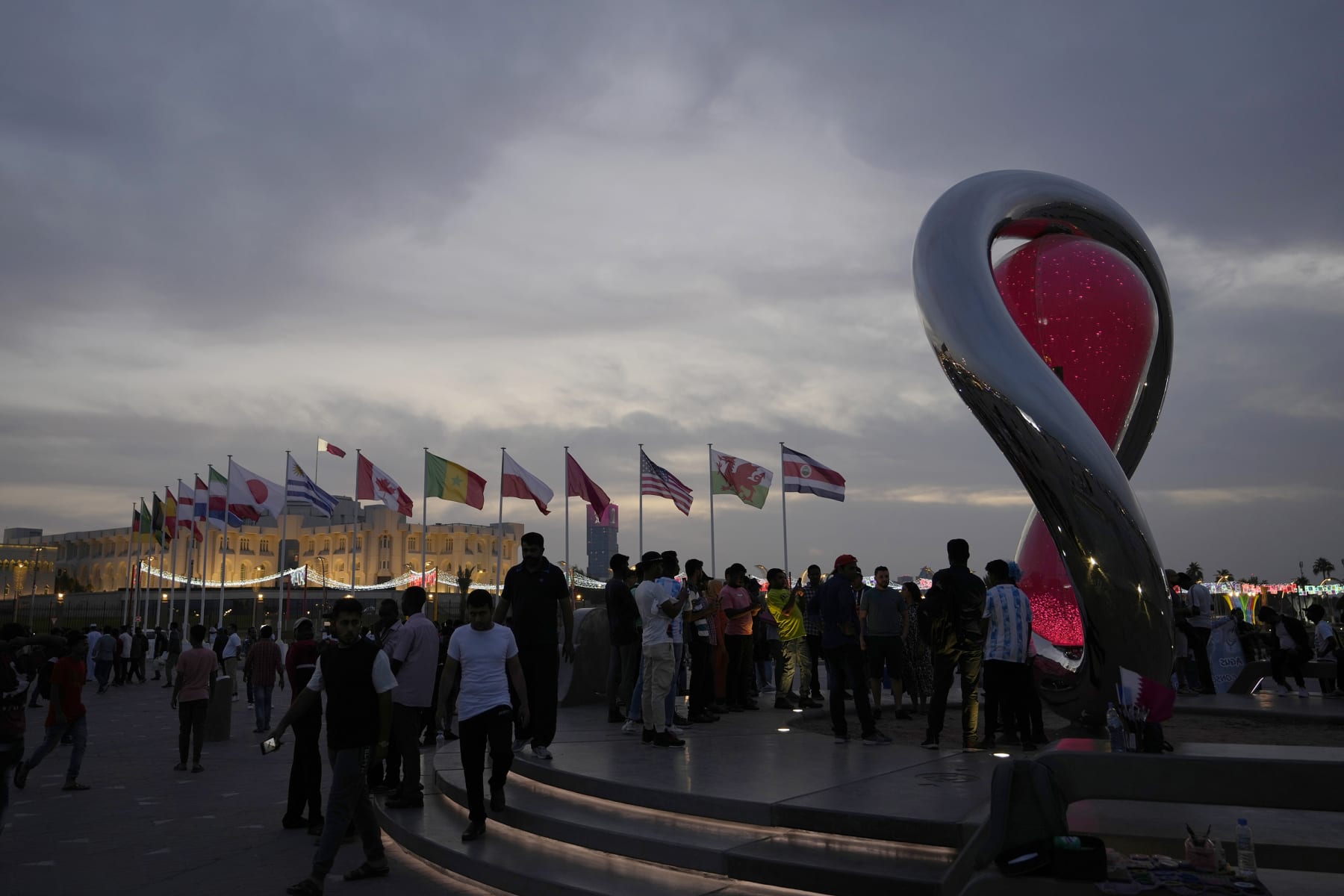 People gather around the official countdown clock showing remaining time until the kick-off of the World Cup 2022 in Doha, Qatar, Thursday, Nov. 17, 2022. Final preparations are being made for the soccer World Cup which starts on Nov. 20 when Qatar face Ecuador. (AP Photo/Hassan Ammar)