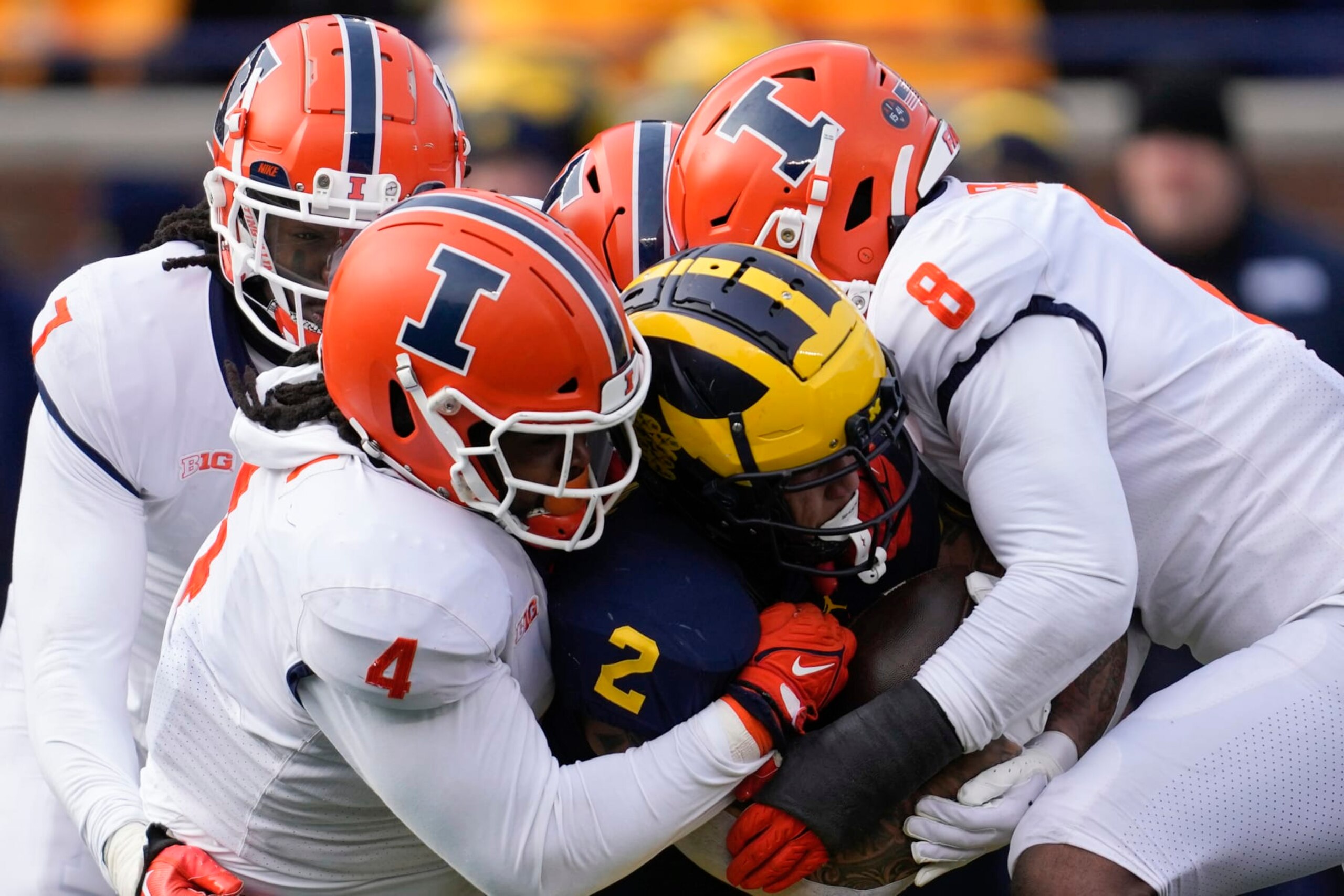 Michigan running back Blake Corum (2) is stopped by Illinois defensive lineman Jer'Zhan Newton (4) and linebacker Tarique Barnes (8) in the first half of an NCAA college football game in Ann Arbor, Mich., Saturday, Nov. 19, 2022. (AP Photo/Paul Sancya) Michigan running back Blake Corum (2) is stopped by Illinois defensive lineman Jer'Zhan Newton (4) and linebacker Tarique Barnes (8) in the first half of an NCAA college football game in Ann Arbor, Mich., Saturday, Nov. 19, 2022. (AP Photo/Paul Sancya)