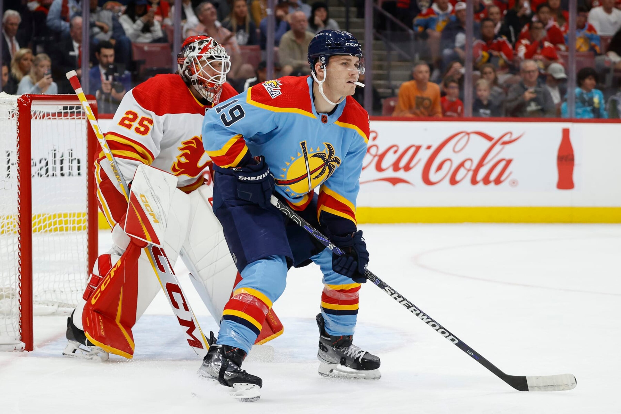 SUNRISE, FL - NOVEMBER 19: Matthew Tkachuk #19 of the Florida Panthers waits for a tip in attempt in front of goaltender Jacob Markstrom #25 of the Calgary Flames at the FLA Live Arena on November 19, 2022 in Sunrise, Florida. (Photo by Joel Auerbach/Getty Images) SUNRISE, FL - NOVEMBER 19: Matthew Tkachuk #19 of the Florida Panthers waits for a tip in attempt in front of goaltender Jacob Markstrom #25 of the Calgary Flames at the FLA Live Arena on November 19, 2022 in Sunrise, Florida. (Photo by Joel Auerbach/Getty Images)