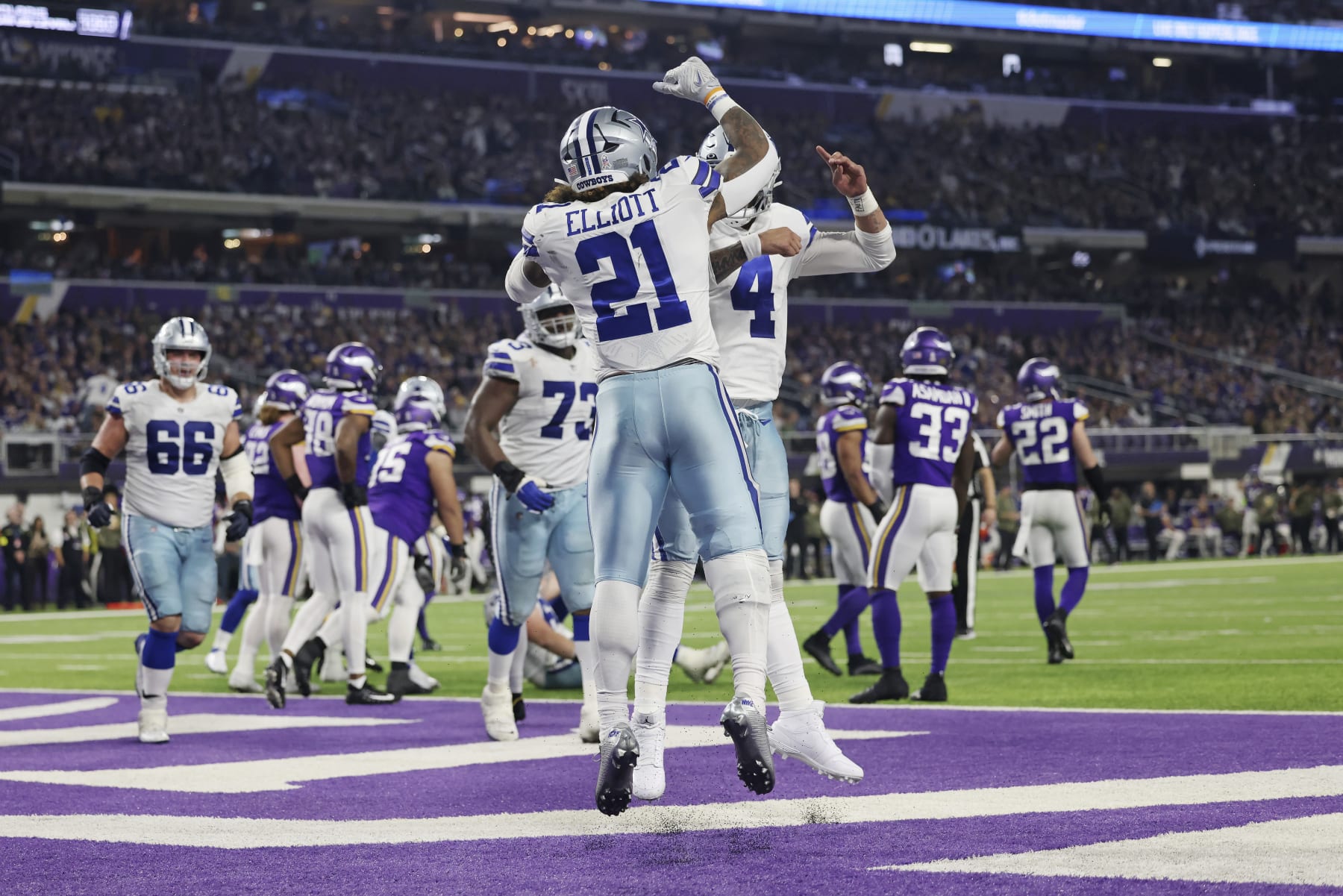Dallas Cowboys running back Ezekiel Elliott (21) celebrates with quarterback Dak Prescott (4) after scoring a touchdown during the second half of an NFL football game Sunday, Nov. 20, 2022 in Minneapolis. (AP Photo/Stacy Bengs)