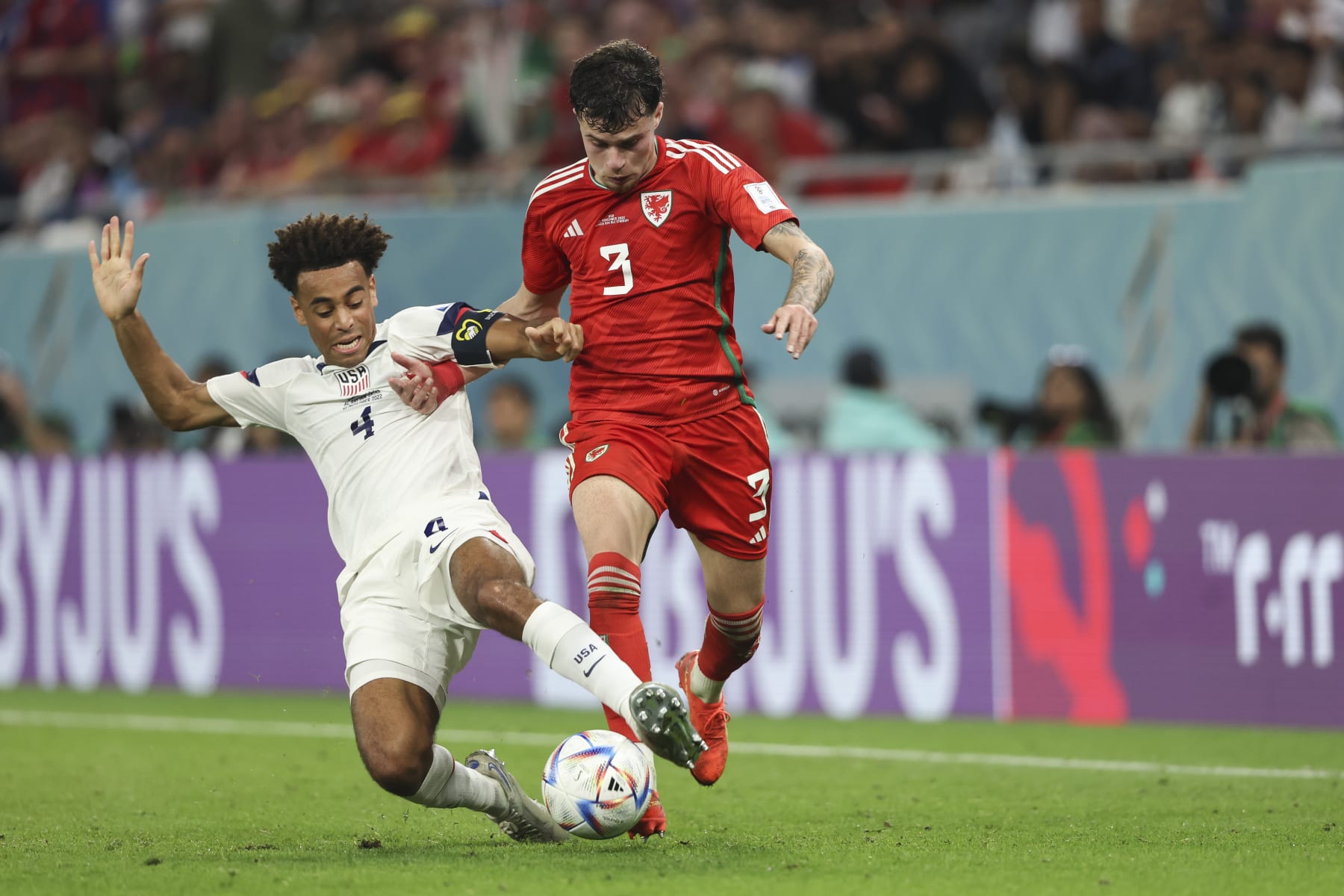 DOHA, QATAR - NOVEMBER 21: Tyler Adams of United States of America and Neco Williams of Wales during the FIFA World Cup Qatar 2022 Group B match between USA and Wales at Ahmad Bin Ali Stadium on November 21, 2022 in Doha, Qatar. (Photo by Matthew Ashton - AMA/Getty Images)