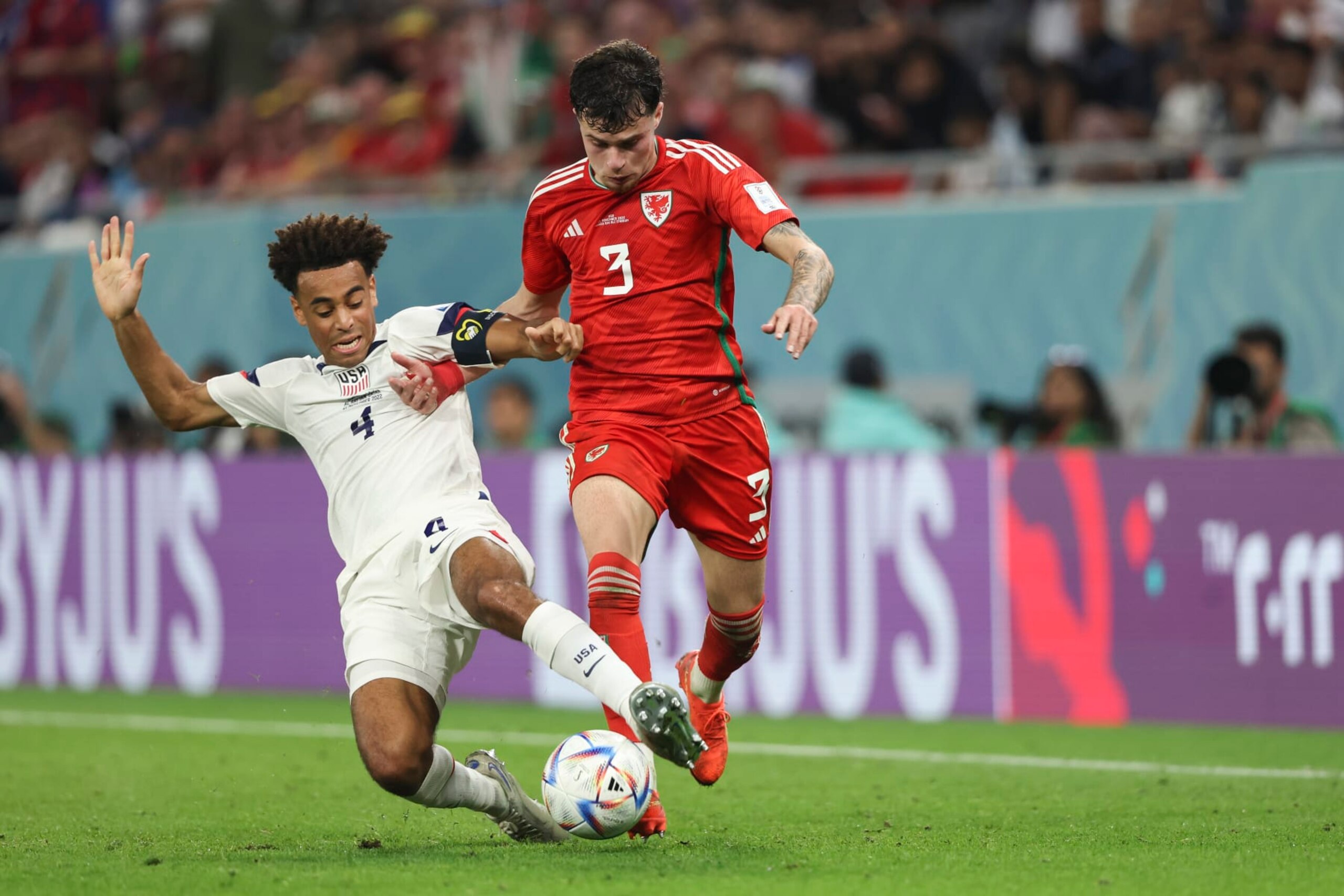 DOHA, QATAR - NOVEMBER 21: Tyler Adams of United States of America and Neco Williams of Wales during the FIFA World Cup Qatar 2022 Group B match between USA and Wales at Ahmad Bin Ali Stadium on November 21, 2022 in Doha, Qatar. (Photo by Matthew Ashton - AMA/Getty Images)