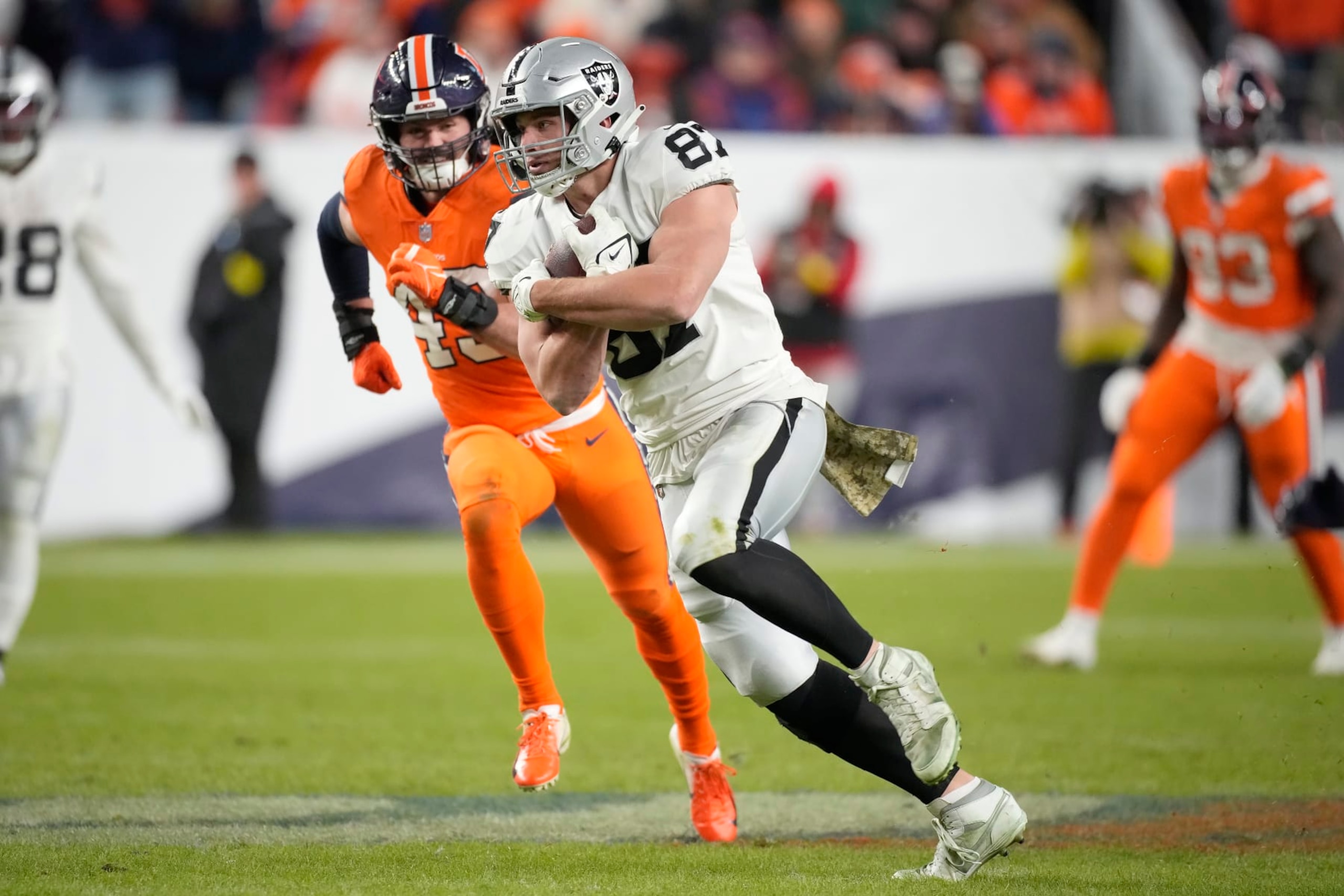 Las Vegas Raiders tight end Foster Moreau (87) runs against Denver Broncos linebacker Alex Singleton during overtime of an NFL football game in Denver, Sunday, Nov. 20, 2022. (AP Photo/David Zalubowski) Las Vegas Raiders tight end Foster Moreau (87) runs against Denver Broncos linebacker Alex Singleton during overtime of an NFL football game in Denver, Sunday, Nov. 20, 2022. (AP Photo/David Zalubowski)