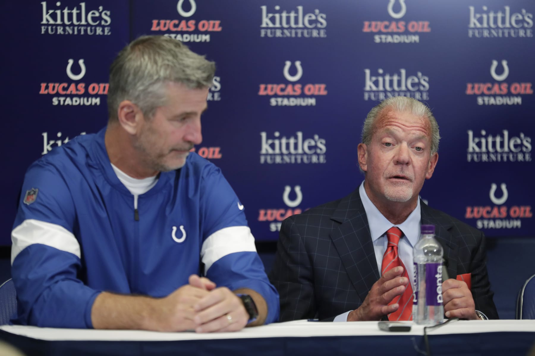 Indianapolis Colts coach Frank Reich listens as team owner Jim Irsay speaks following a news conference after the Colts' NFL preseason football game against the Chicago Bears, Saturday, Aug. 24, 2019, in Indianapolis. Colts quarterback Andrew Luck announced that he his retiring at age 29. (AP Photo/Michael Conroy)