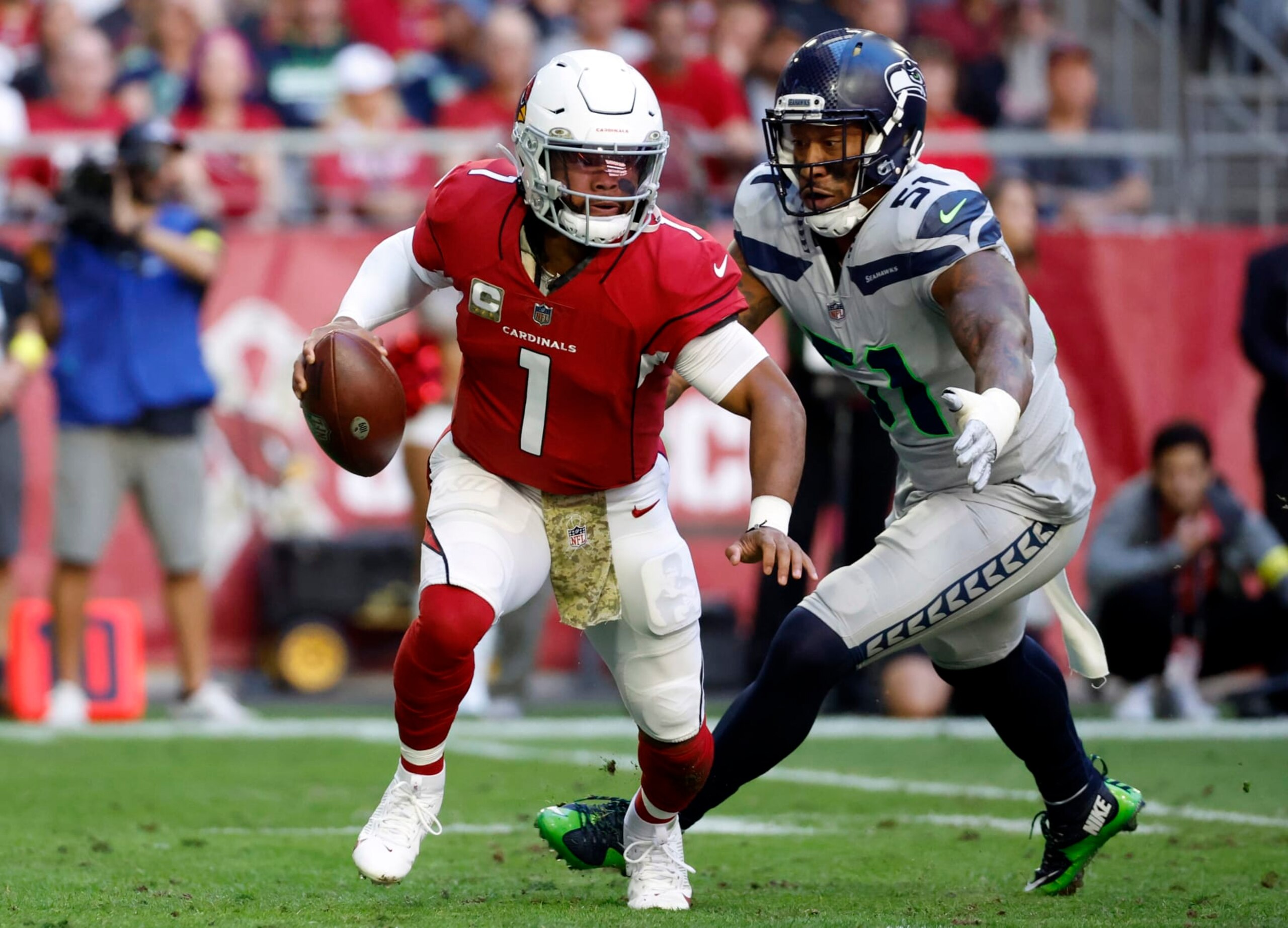 GLENDALE, ARIZONA - NOVEMBER 06: Quarterback Kyler Murray #1 of the Arizona Cardinals runs under pressure from linebacker Bruce Irvin #51 of the Seattle Seahawks during the first half at State Farm Stadium on November 06, 2022 in Glendale, Arizona. The Seahawks beat the Cardinals 31-21. (Photo by Chris Coduto/Getty Images)