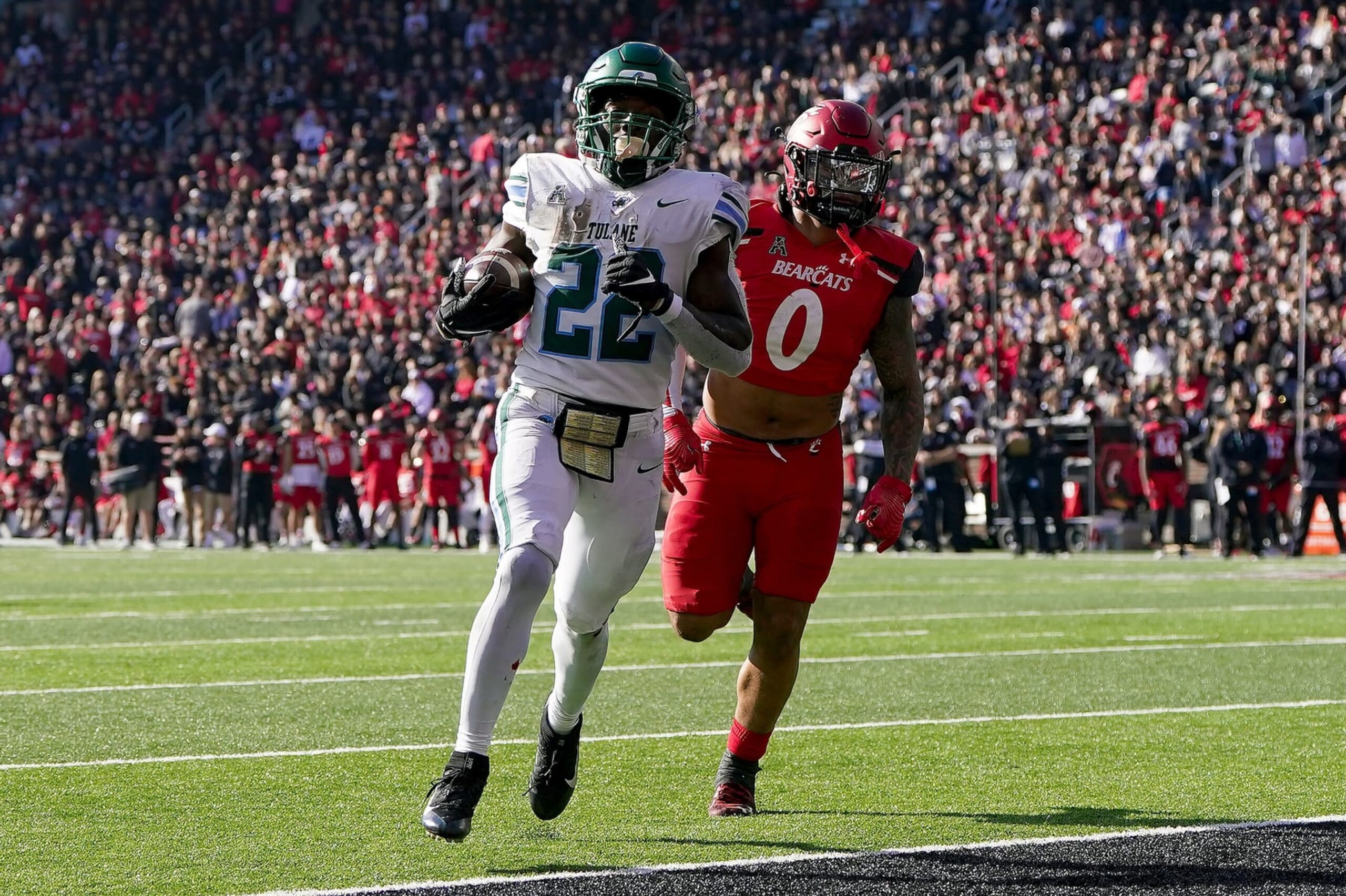 CINCINNATI, OHIO - NOVEMBER 25: Tyjae Spears #22 of the Tulane Green Wave scores a touchdown past Ivan Pace Jr. #0 of the Cincinnati Bearcats in the second quarter at Nippert Stadium on November 25, 2022 in Cincinnati, Ohio. (Photo by Dylan Buell/Getty Images) CINCINNATI, OHIO - NOVEMBER 25: Tyjae Spears #22 of the Tulane Green Wave scores a touchdown past Ivan Pace Jr. #0 of the Cincinnati Bearcats in the second quarter at Nippert Stadium on November 25, 2022 in Cincinnati, Ohio. (Photo by Dylan Buell/Getty Images)