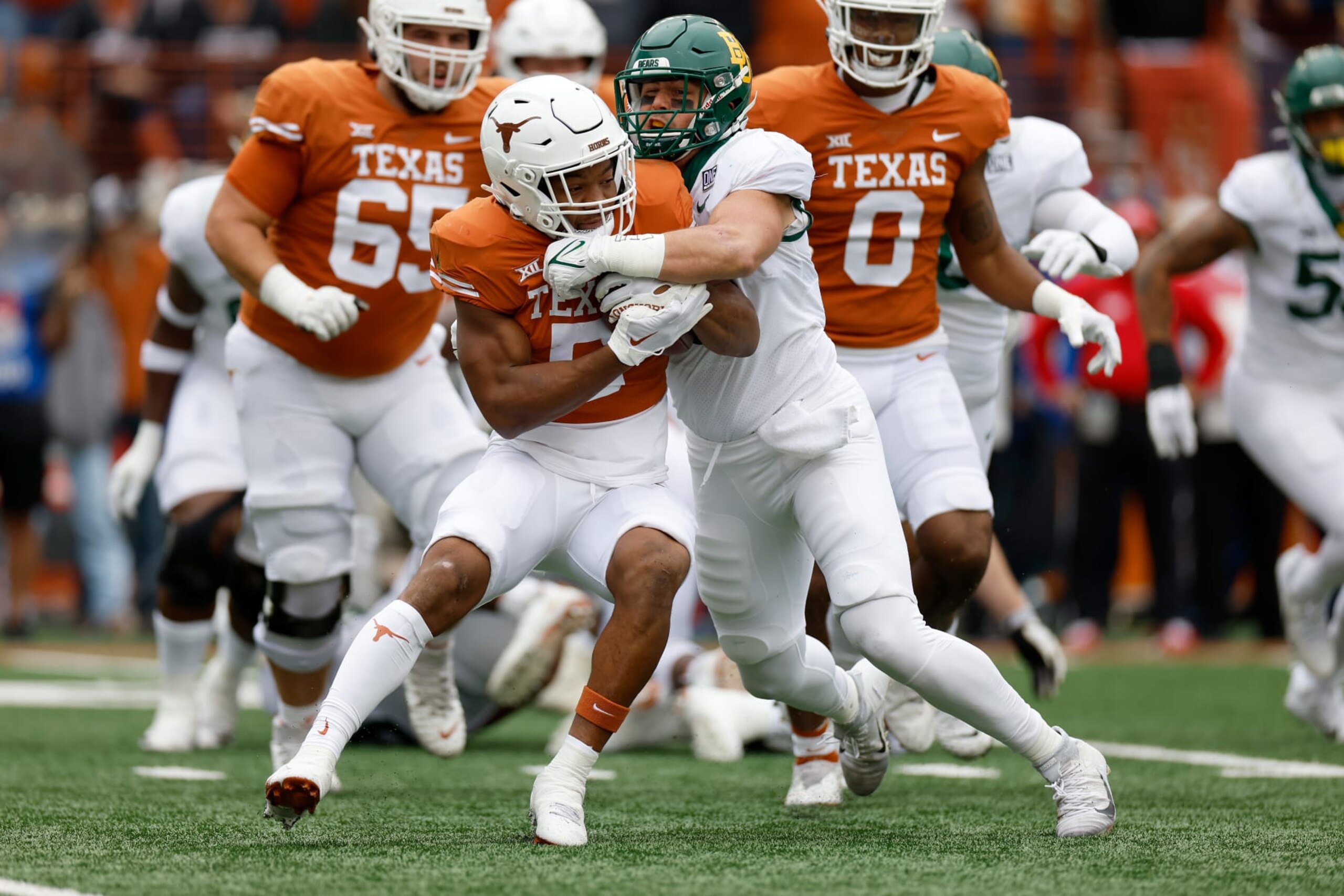 AUSTIN, TEXAS - NOVEMBER 25: Dillon Doyle #5 of the Baylor Bears tackles Bijan Robinson #5 of the Texas Longhorns for a loss in the first half at Darrell K Royal-Texas Memorial Stadium on November 25, 2022 in Austin, Texas. (Photo by Tim Warner/Getty Images) AUSTIN, TEXAS - NOVEMBER 25: Dillon Doyle #5 of the Baylor Bears tackles Bijan Robinson #5 of the Texas Longhorns for a loss in the first half at Darrell K Royal-Texas Memorial Stadium on November 25, 2022 in Austin, Texas. (Photo by Tim Warner/Getty Images)
