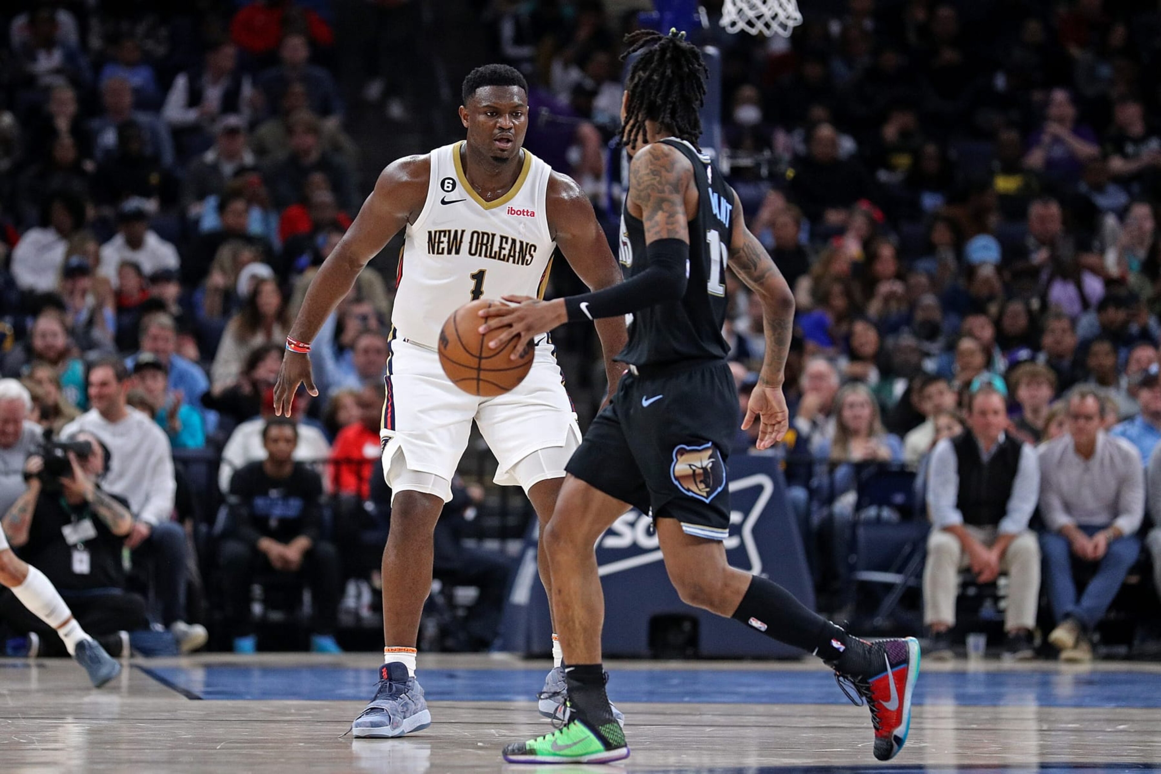 MEMPHIS, TENNESSEE - NOVEMBER 25: Ja Morant #12 of the Memphis Grizzlies handles the ball against Zion Williamson #1 of the New Orleans Pelicans during the first half at FedExForum on November 25, 2022 in Memphis, Tennessee. NOTE TO USER: User expressly acknowledges and agrees that, by downloading and or using this photograph, User is consenting to the terms and conditions of the Getty Images License Agreement. (Photo by Justin Ford/Getty Images)
